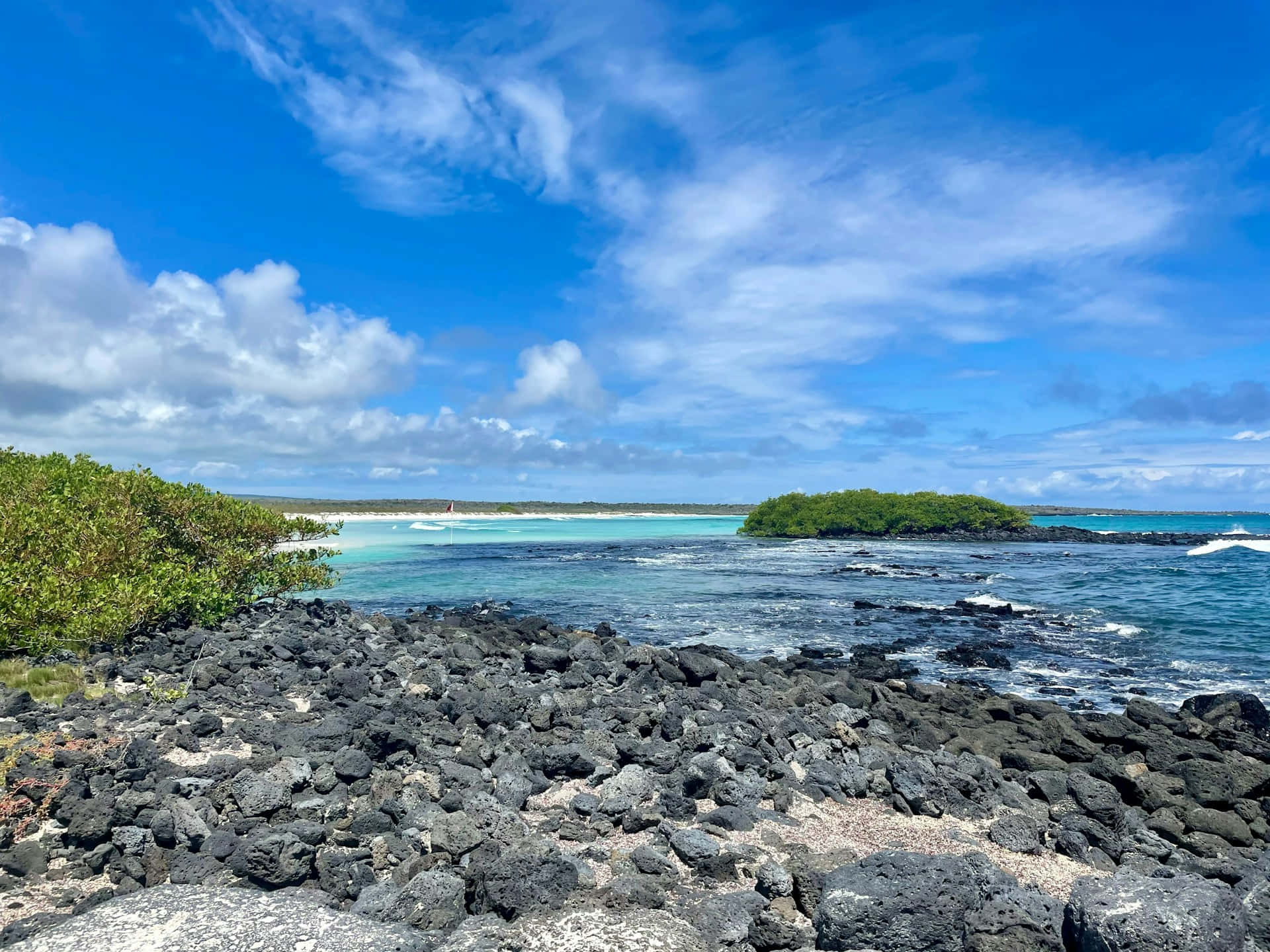  壁紙 — 充滿活力的藍綠色海水撞擊黑色火山岩，上方是明亮的藍天和蓬鬆的白雲。