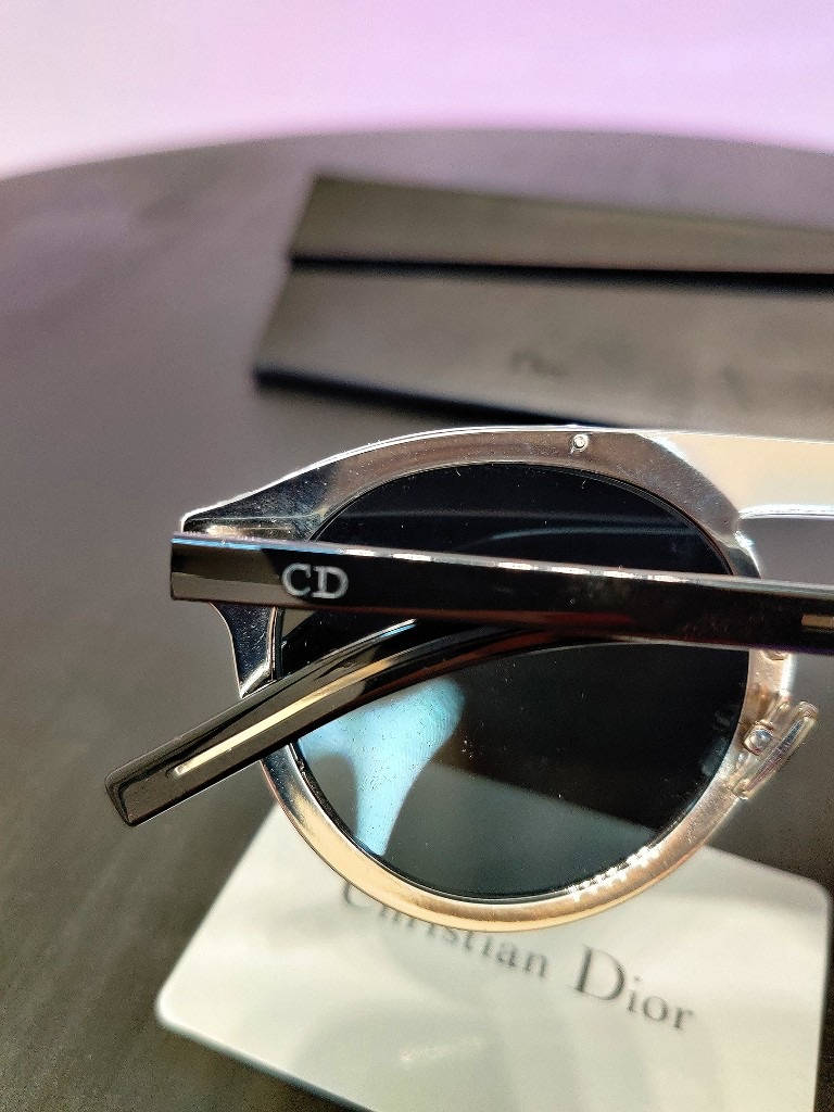Christian Dior 黑色太陽眼鏡 壁紙 — Christian Dior 時尚太陽眼鏡特寫，金屬鏡框配黑色鏡片，放在品牌盒上。
