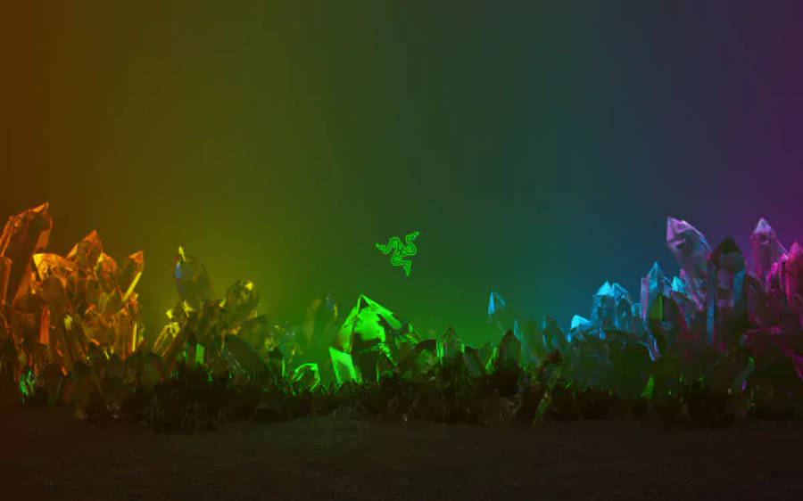 雷蛇 Chroma 水晶 4K 壁紙 — 發光的晶體結構在漸變天空下以鮮豔的彩虹色調脈動，並帶有發光的 Razer 標誌。