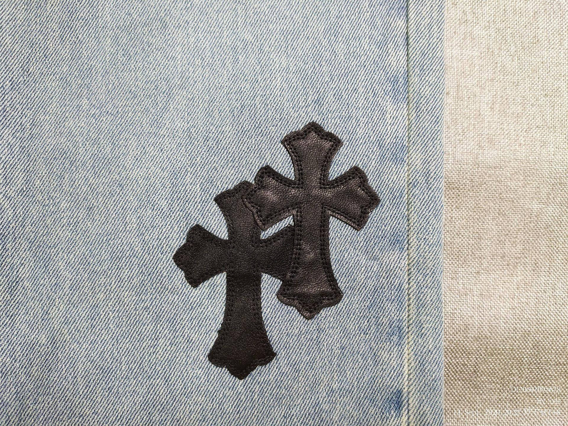 Chrome Hearts 標誌補丁 壁紙 — 兩個黑色皮革十字補丁縫在淺藍色牛仔褲上，帶有米色布料接縫。