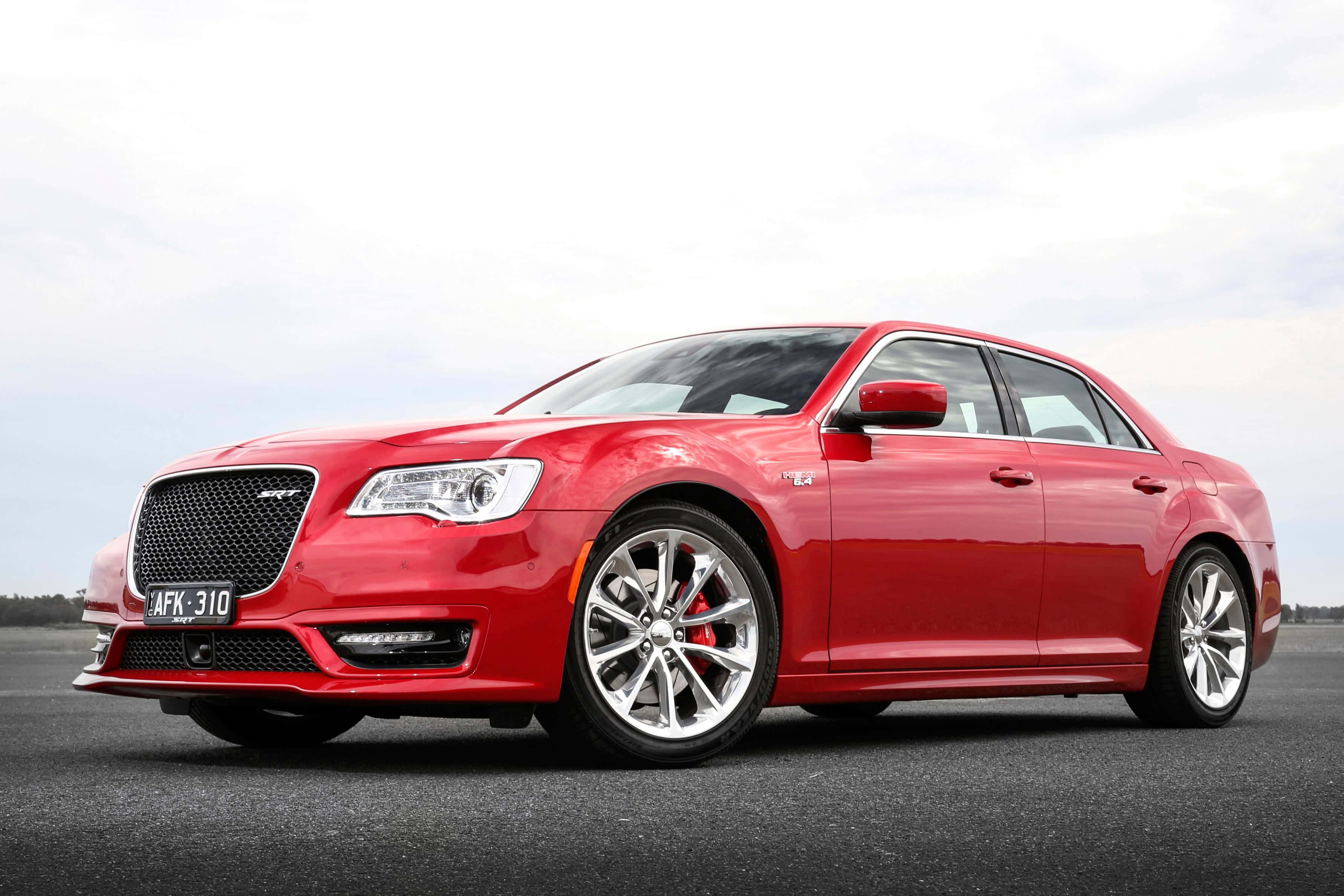 Chrysler與戶外，完美搭配！ 壁紙 — 一架光澤紅色Chrysler 300 SRT房車，配備銀色輪圈和紅色制動卡鉗，停泊在陰天下的瀝青路面上。
