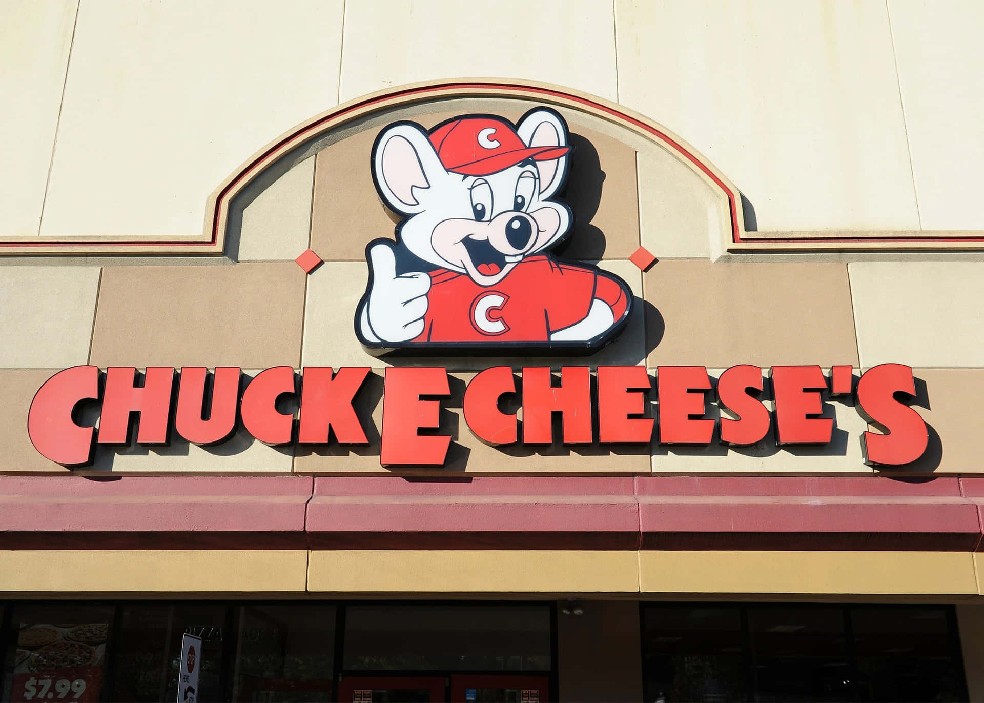 Chuck E Cheese 吉祥物在餐廳招牌上方豎起大拇指。