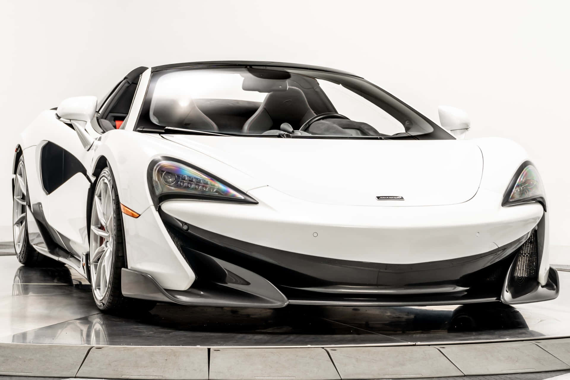Mclaren 600lt Spider 桌布 壁紙 — 一輛帶有黑色點綴和時尚空氣動力學設計的純白色McLaren跑車在明亮的攝影棚中展示。