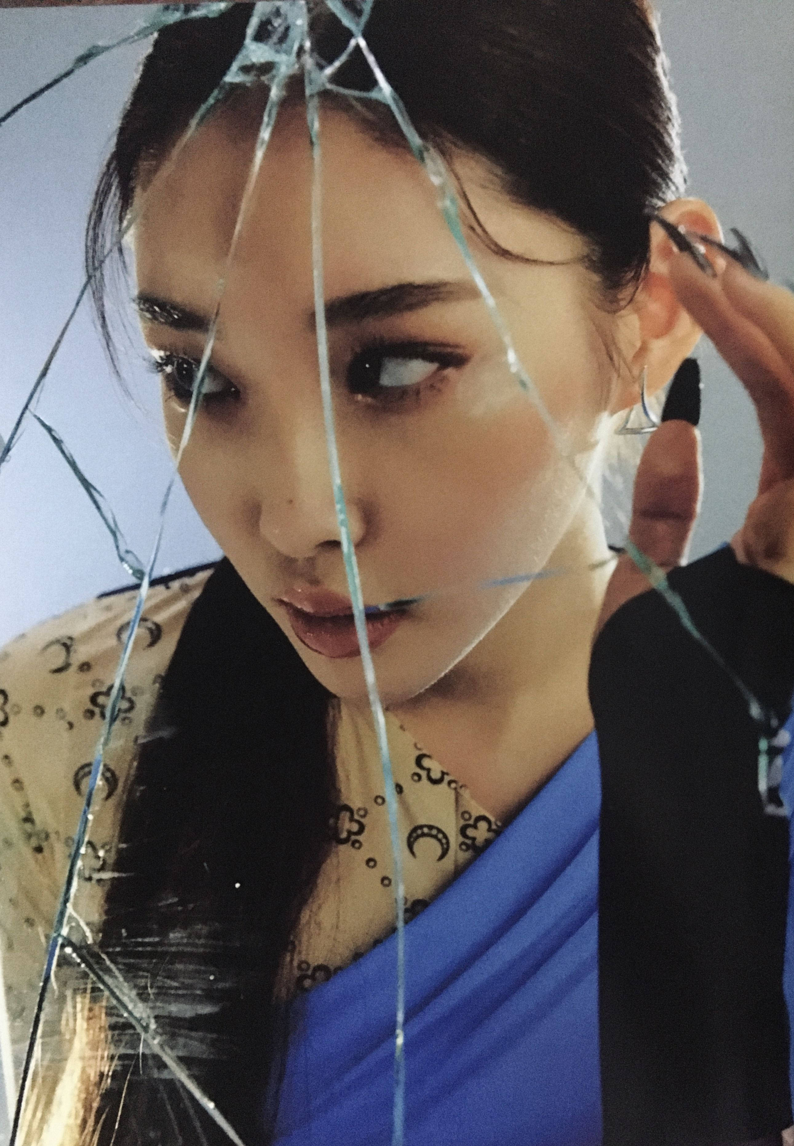 Chungha 創意鏡像照 壁紙 — 一位深色頭髮、妝容大膽的女性，透過碎裂的玻璃凝視，同時調整她的耳環。