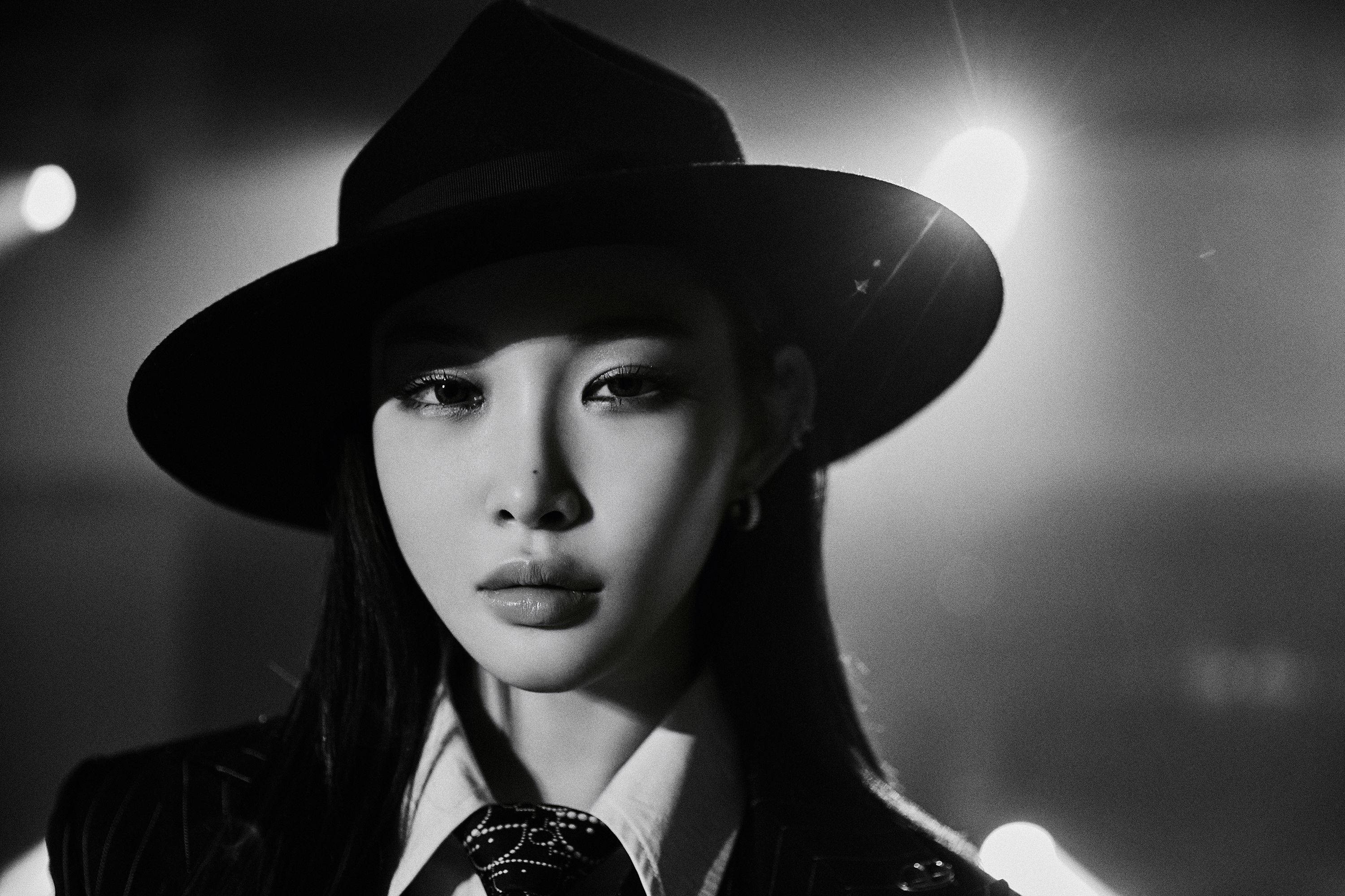 Chungha 《Dream of You》 壁紙 — 一位戴寬邊帽的女性的引人注目的黑白肖像，具有戲劇性的燈光和強烈的凝視。