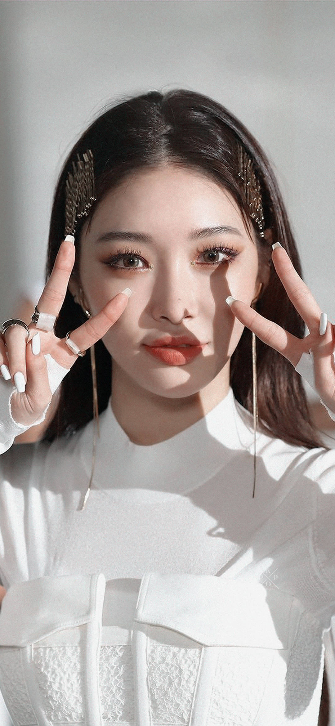 Chungha 可愛自拍 壁紙 — 一位黑髮白指甲的年輕女性，在明亮的陽光下穿著白色質感上衣，用手指框住臉部。