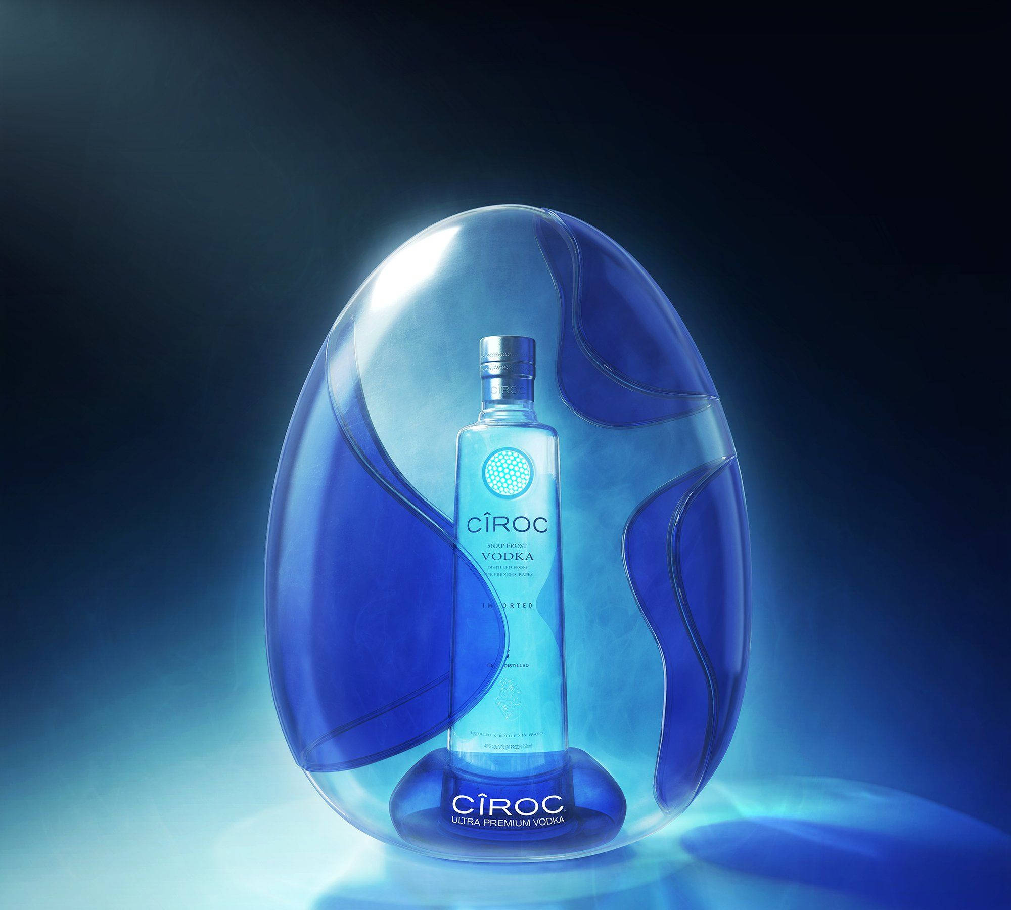 Ciroc超級優質法國伏特加瓶 壁紙 — 一個時尚的藍色Ciroc伏特加酒瓶在深色漸變背景下的半透明藍色雕刻蛋內發光。