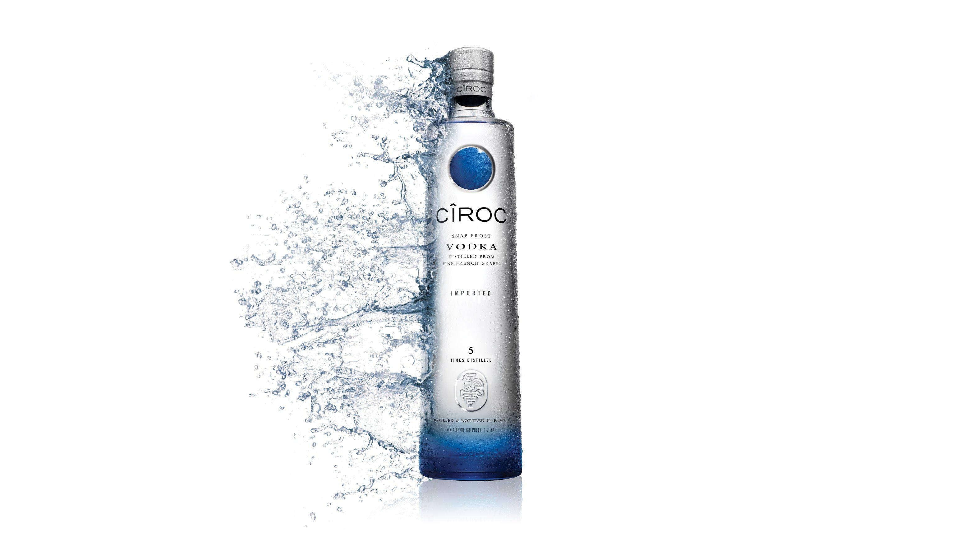 Ciroc 法國伏特加瓶身水花飛濺圖形藝術 壁紙 — 一個時尚的銀色Ciroc伏特加酒瓶帶有藍色點綴，立於白色背景前，動態的水花在其底部周圍戲劇性地飛濺。