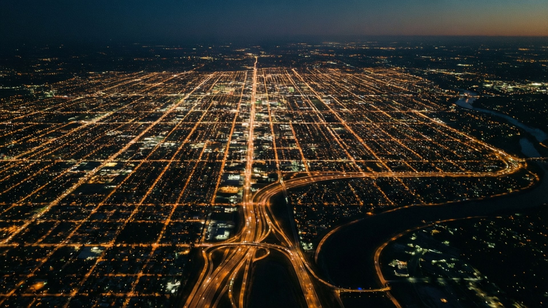 夜晚城市網格的空中景觀，發光的街道和高速公路蜿蜒穿過黑暗的土地。