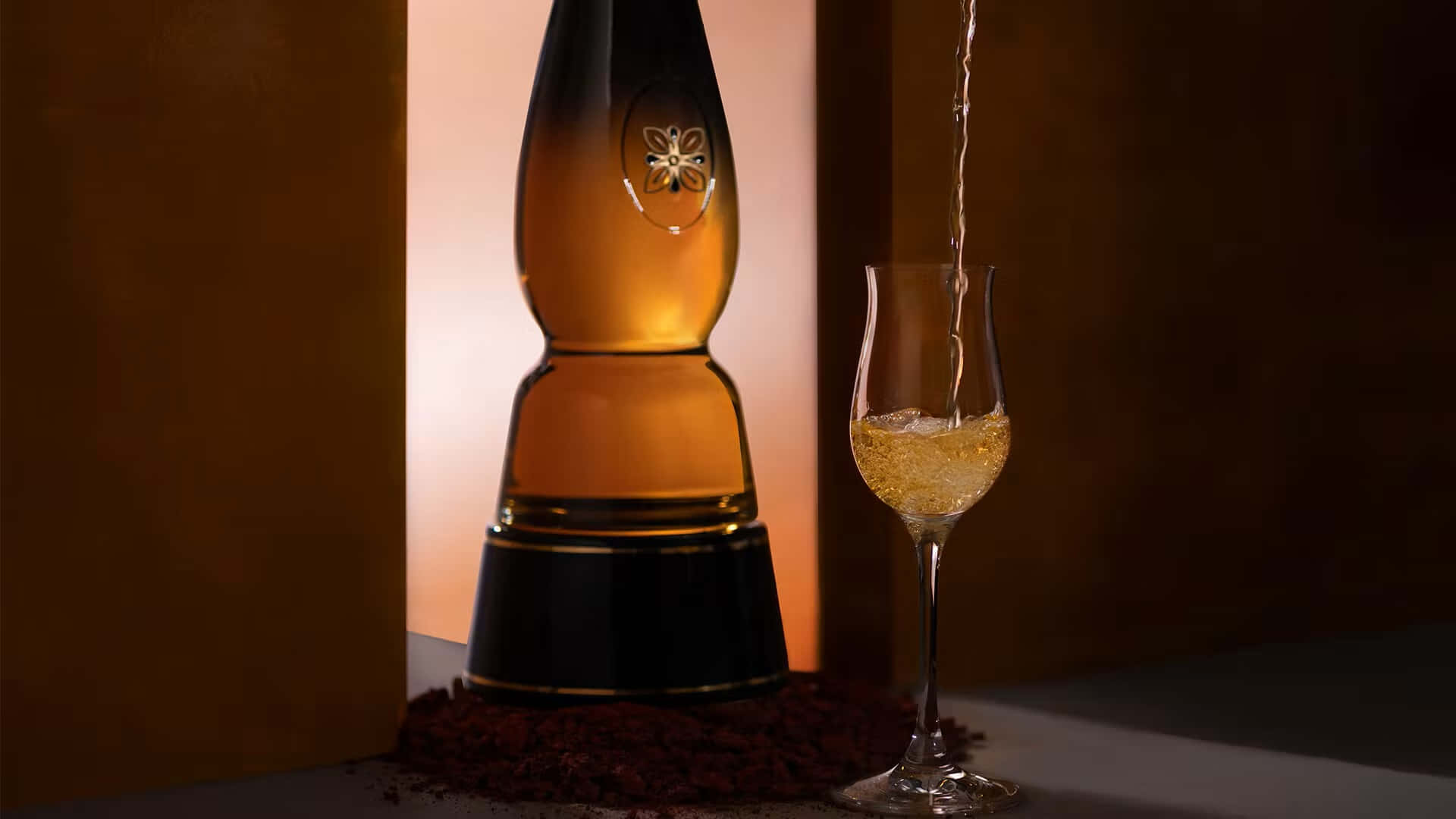金色香檳從瓶子倒入笛形杯，在溫暖的燈光下。
