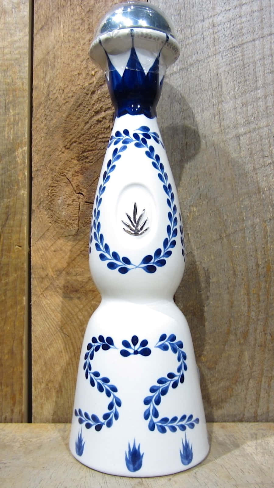 裝飾性藍白陶瓷龍舌蘭酒瓶在木質表面上。