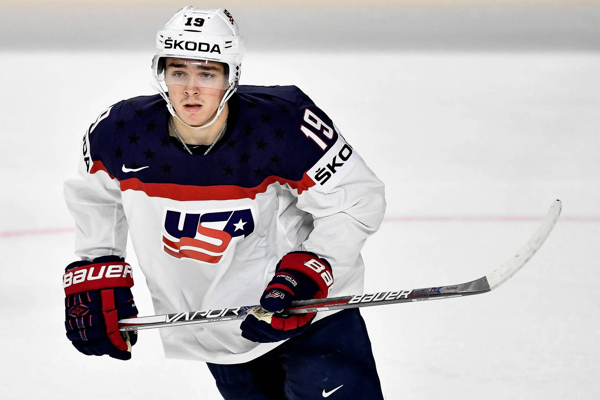 Clayton Keller 2017 IIHF世界冰球錦標賽 壁紙 — 一位專注的美國冰球運動員穿著愛國球衣，持棍在冰場上滑行。