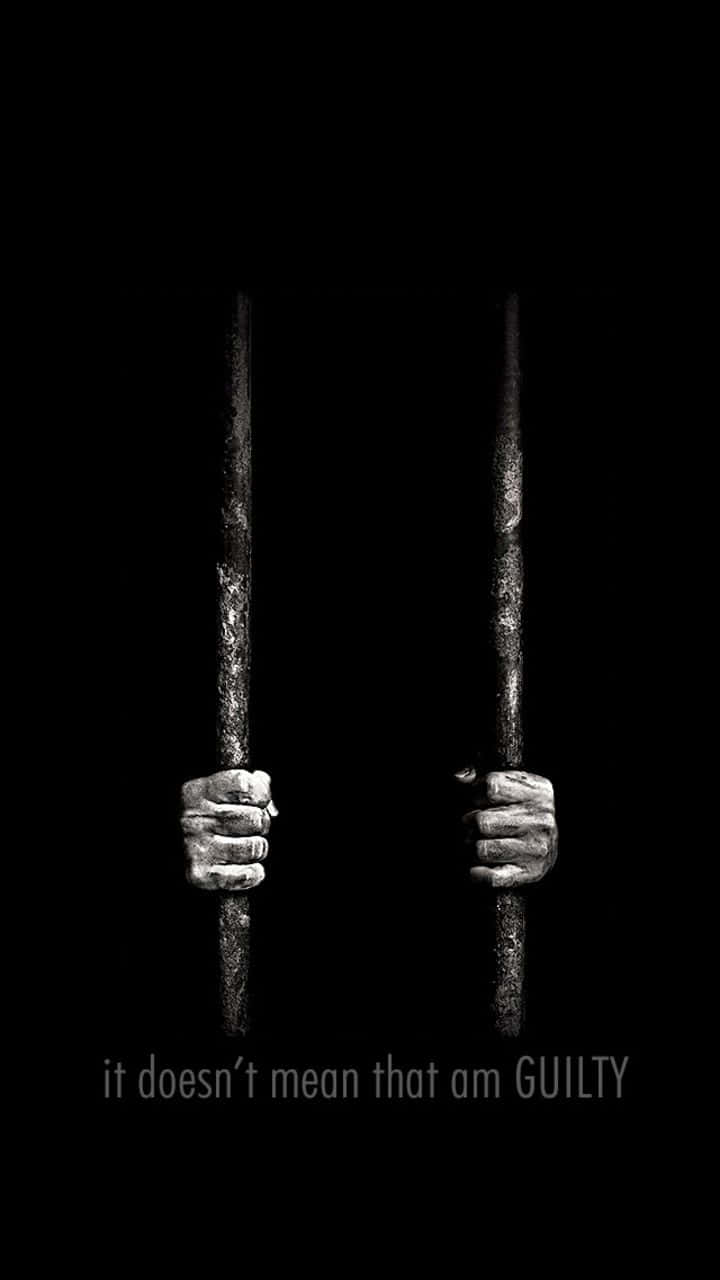 Clever iPhone警示圖：手被鎖在牢籠內 壁紙 — 兩個緊握的拳頭抓住生鏽的監獄鐵欄杆，背景為黑色，文字寫著這並不代表我有罪。