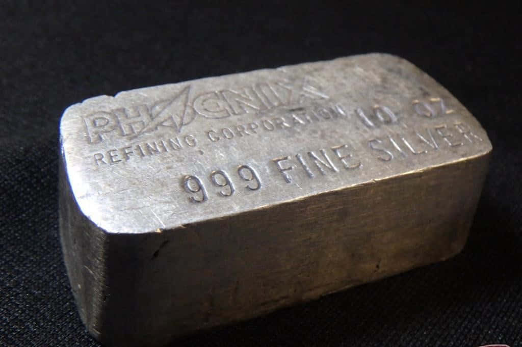 銀色 桌布 壁紙 — Phaenix Refining Corporation 的 10 盎司 999 純銀條特寫，放置在深色紋理表面上。