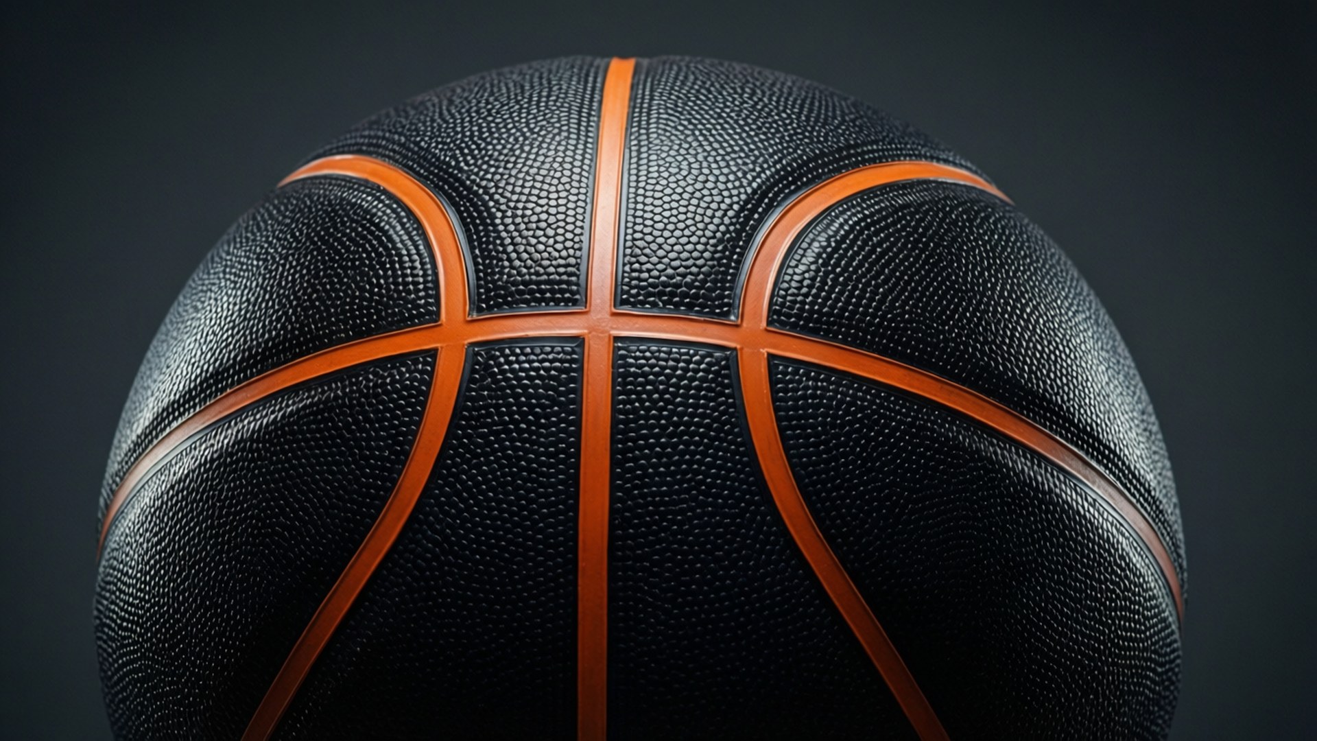 Glossy Black Basketball 壁紙 — 一個黑色籃球的近距離特寫，帶有橙色縫線，背景為深灰色。