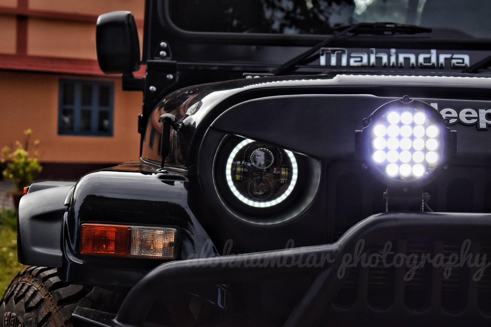 黑色Mahindra Jeep，帶有發光LED頭燈和堅固前保險槓。
