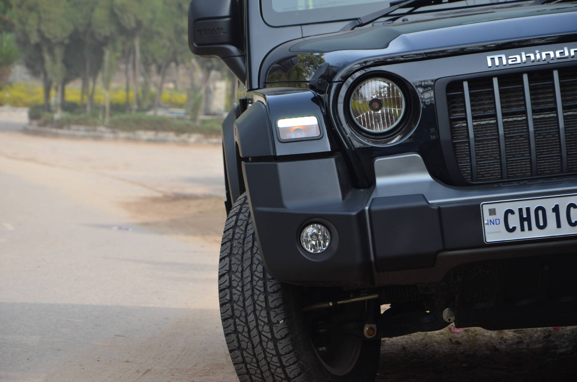 黑色Mahindra Thar SUV在塵土飛揚的道路上的正面視圖