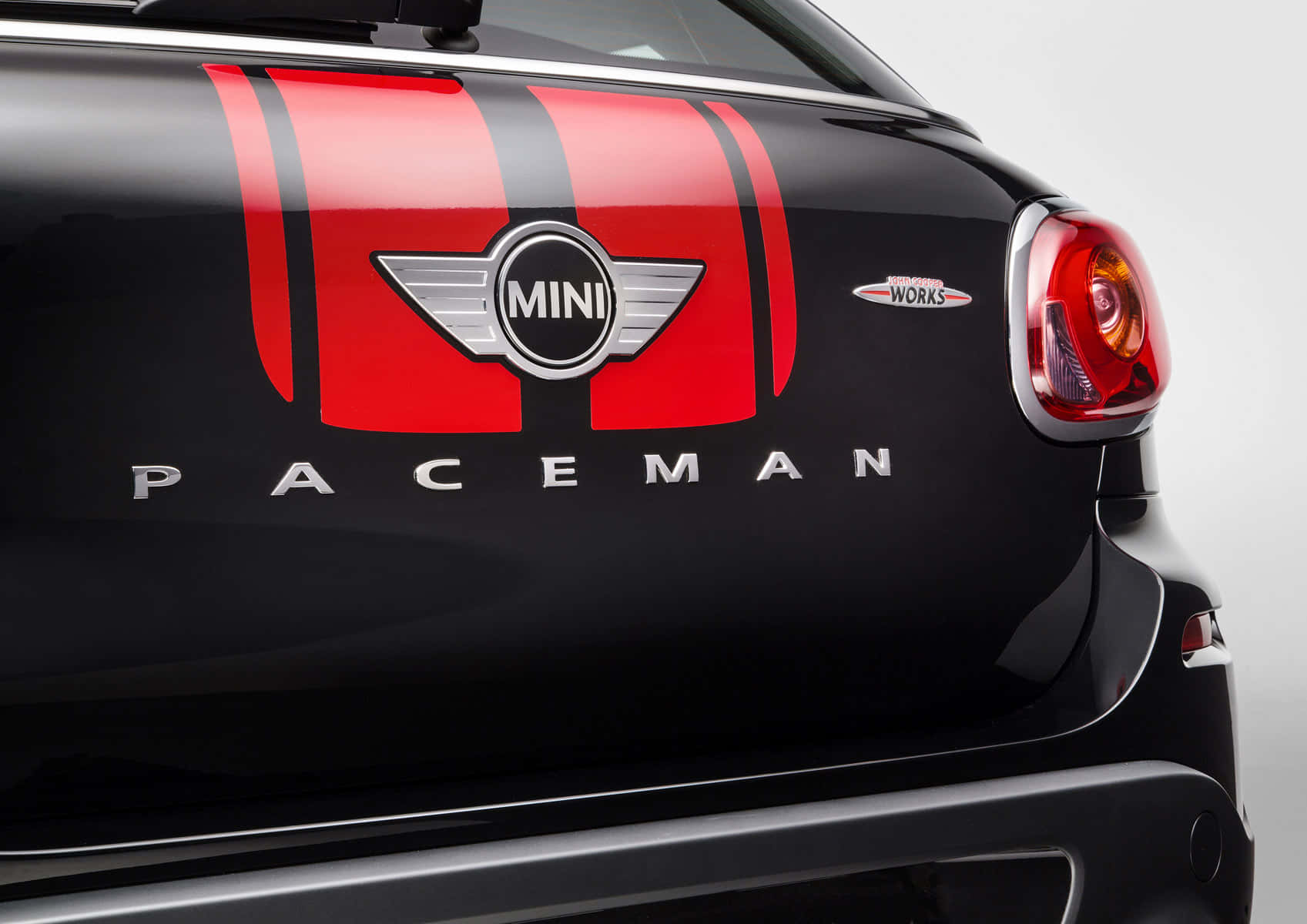  壁紙 — 黑色MINI Paceman車尾特寫，展示紅色賽車條紋和鍍鉻徽章，背景為中性攝影棚。