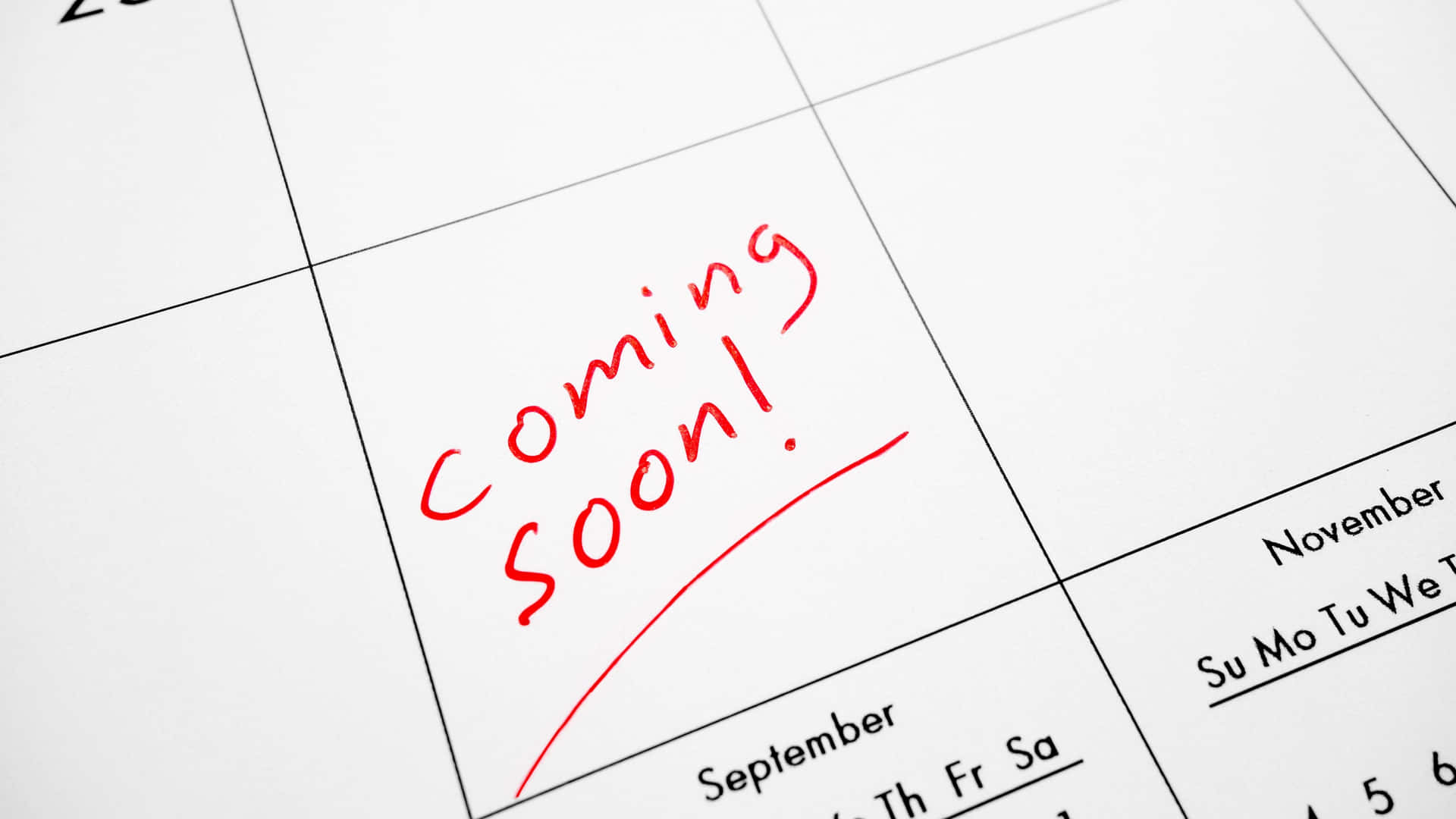 日曆頁面，上面有紅色手寫字條寫著「Coming Soon!」