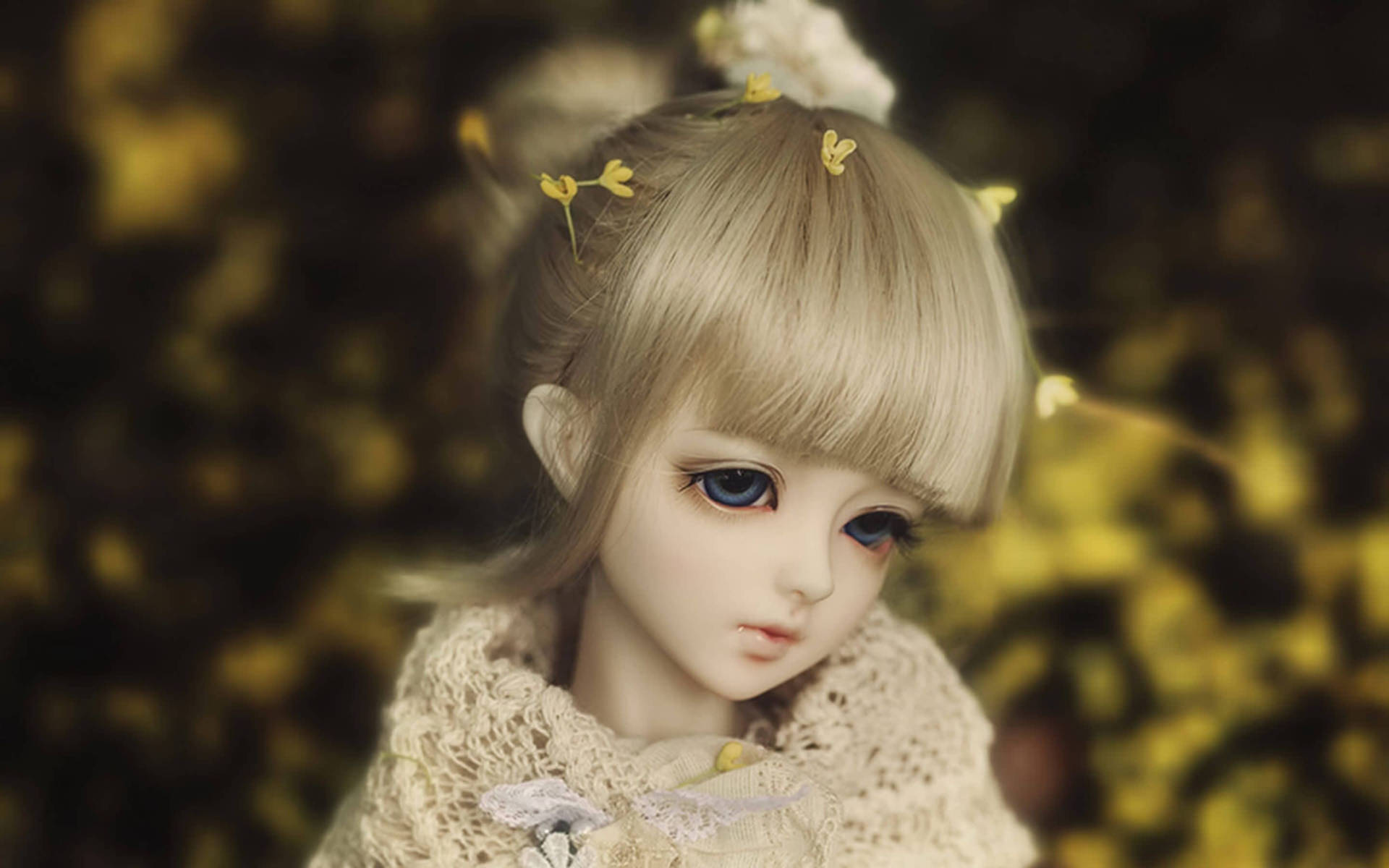 一個金髮藍眼的娃娃，穿著蕾絲衣服，頭髮上戴著黃色花朵。