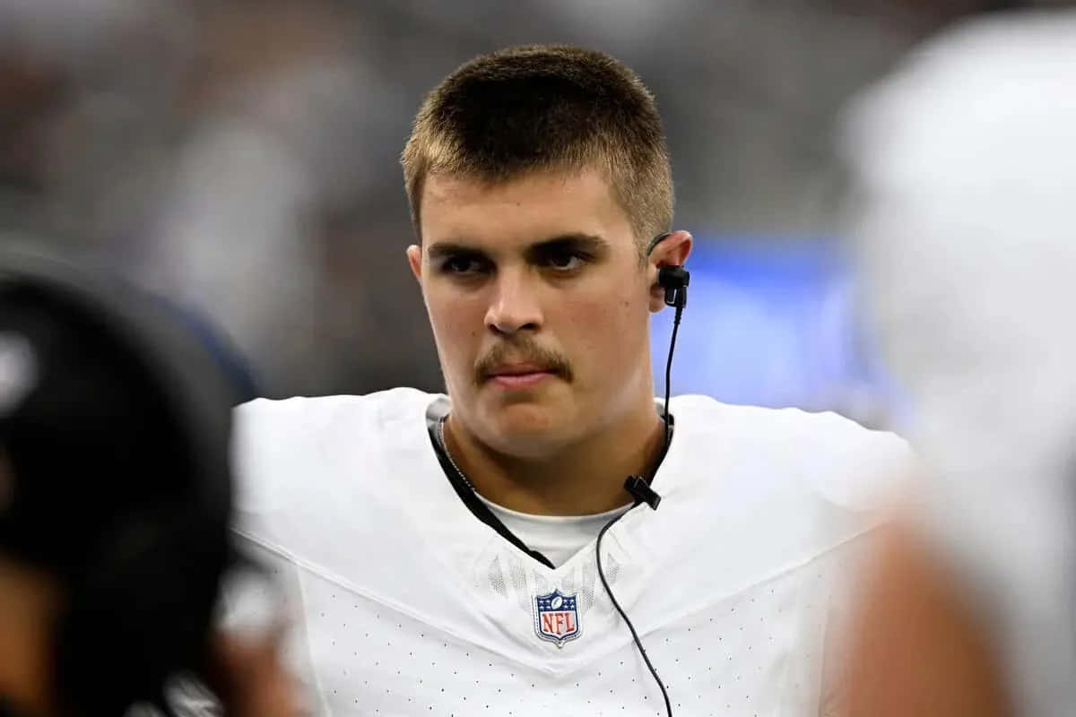  壁紙 — 專注的NFL四分衛身穿白色球衣戴耳機比賽的特寫。