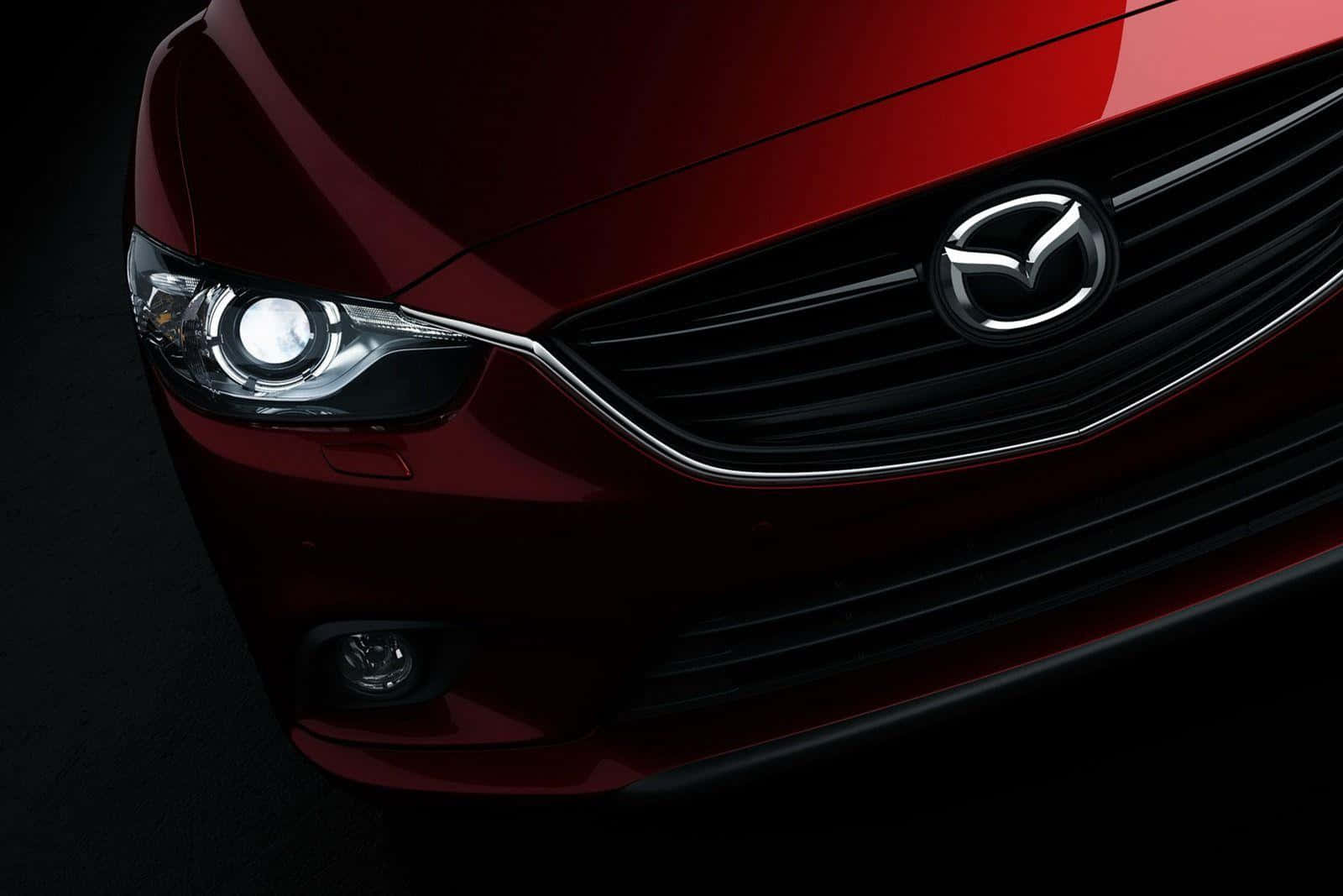 Mazda 6 桌布 壁紙 — 特寫鏡頭：一輛亮紅色萬事得汽車的前格柵和頭燈，背景為深色。