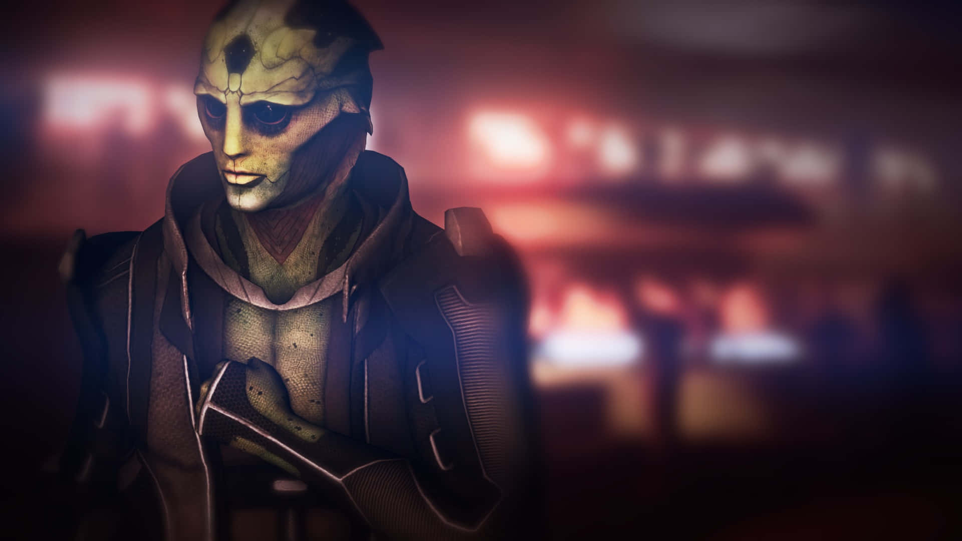 Thane Krios 桌布 壁紙 — 一個綠色皮膚、深色眼睛、身穿連帽外套的外星人特寫，背景昏暗模糊，帶有溫暖的紅光。