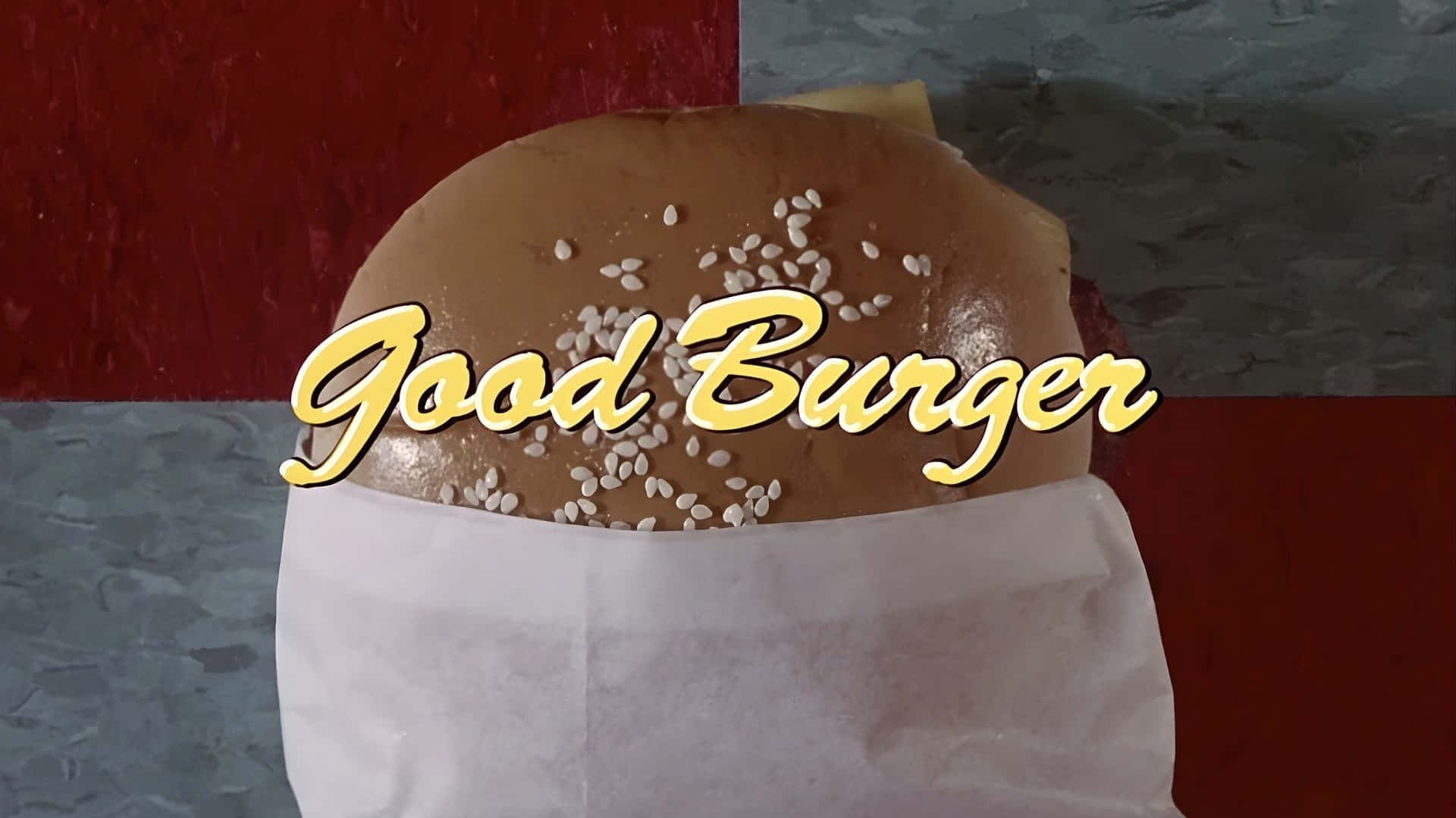  壁紙 — 芝麻漢堡包以紙包裹，並在紅色和灰色紋理背景上疊加「Good Burger」文字的近距離特寫。