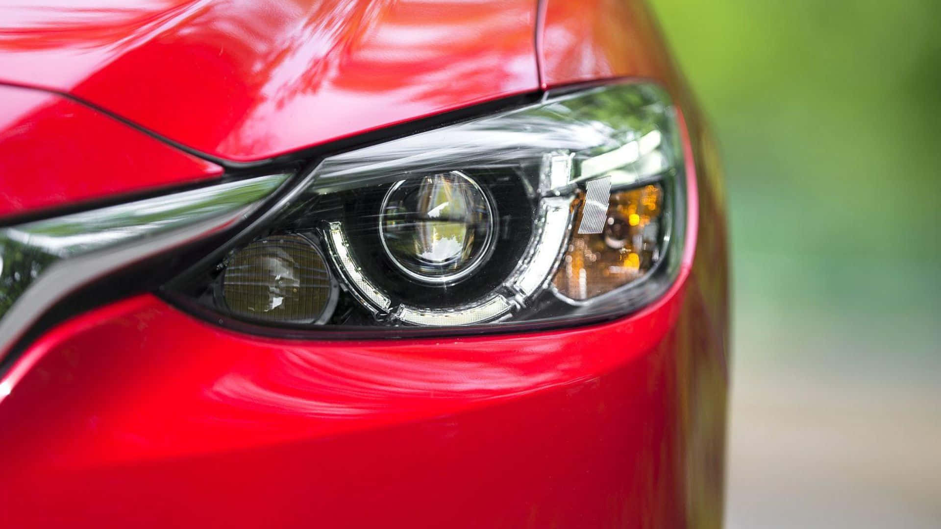 Mazda 6 桌布 壁紙 — 時尚紅色汽車現代車頭燈的特寫，帶有鍍鉻裝飾和發光的琥珀色轉向信號燈。