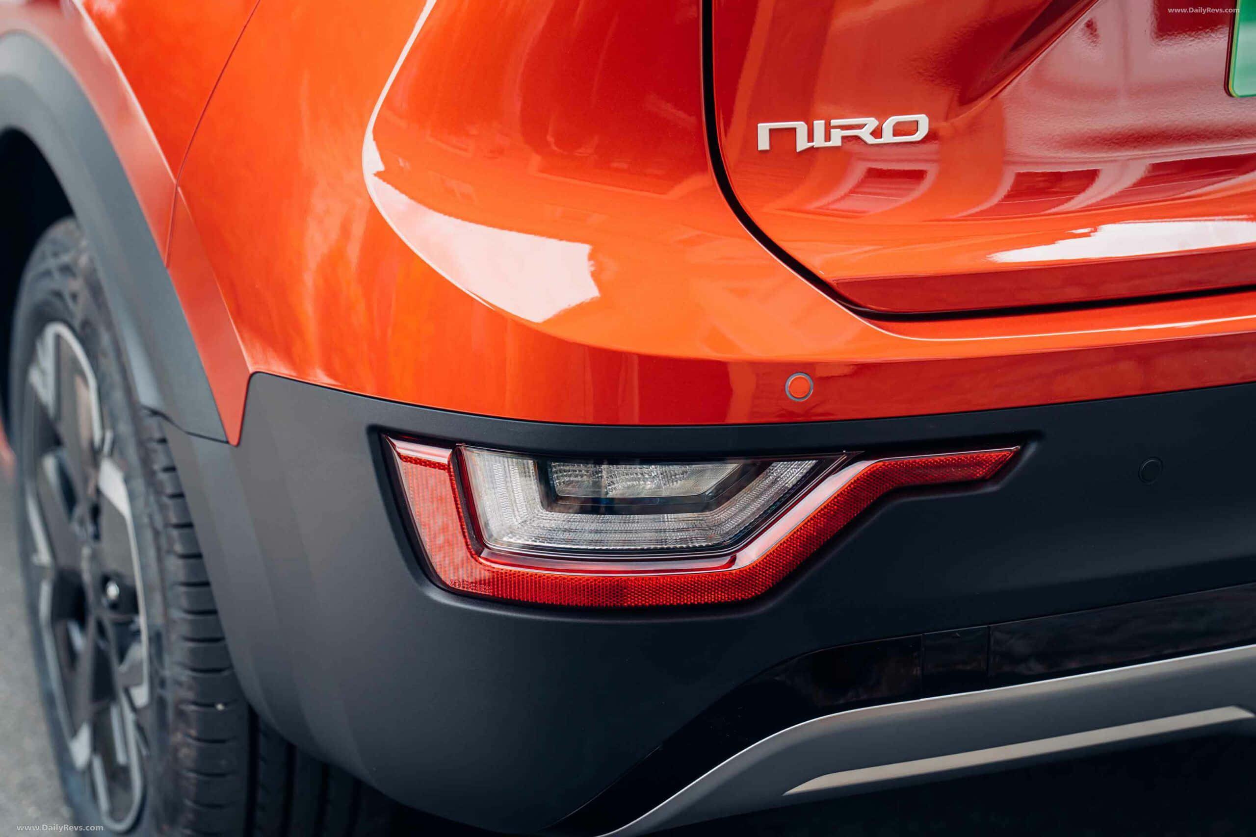Kia Niro 桌布 壁紙 — 近距離拍攝充滿活力的橙色現代Niro車尾，展示時尚尾燈設計和光澤表面。