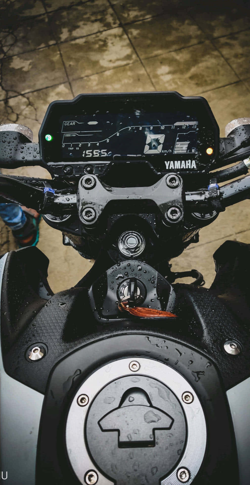  壁紙 — 濕咗嘅Yamaha電單車儀表板同油缸嘅特寫，雨滴喺黑色金屬同石屎地面閃閃發光。