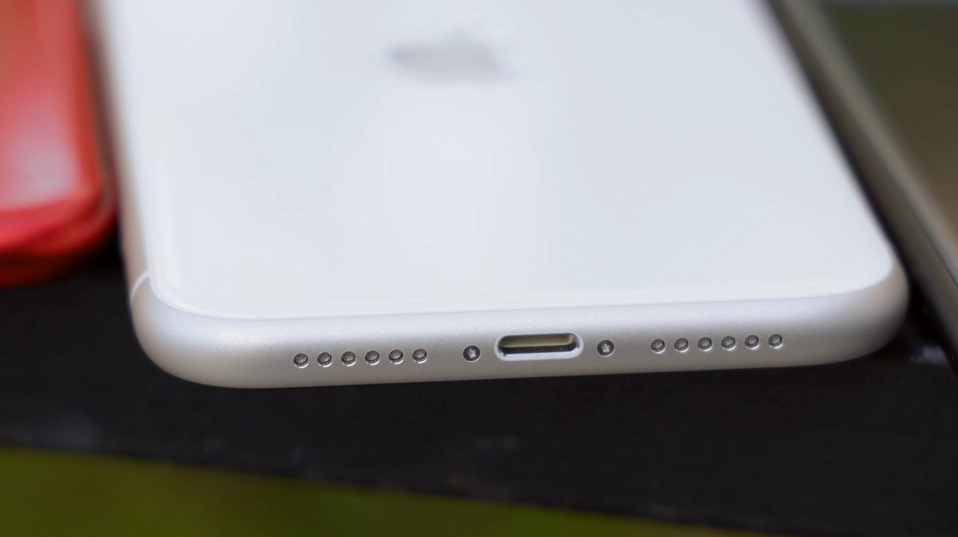 白色iPhone底部的特寫，帶有充電端口和揚聲器孔。