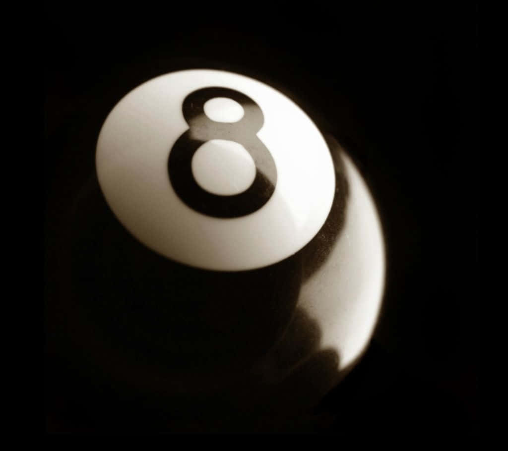  壁紙 — 白色桌球8號球在黑暗背景中亮起的特寫。