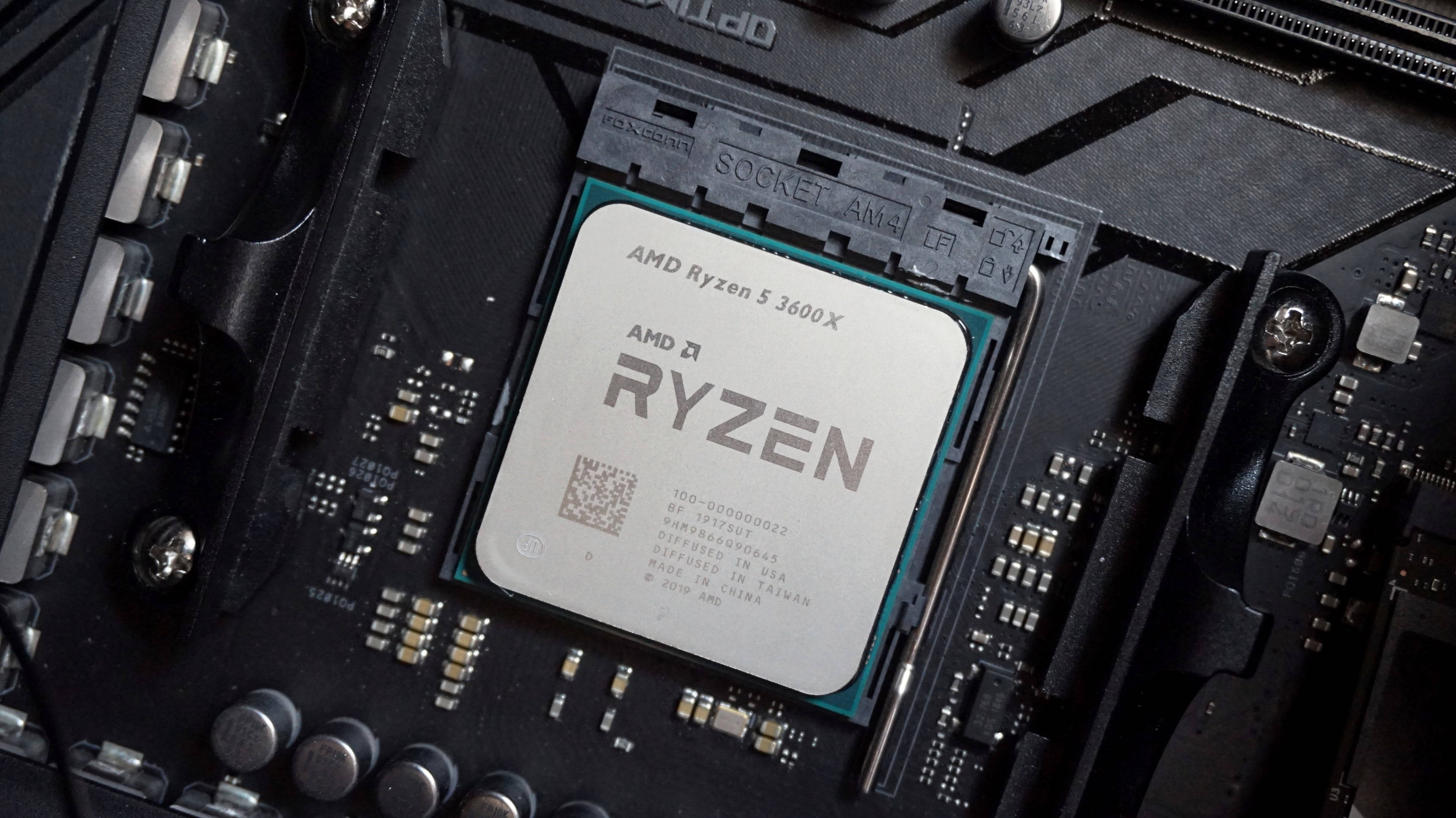 4K 桌布 壁紙 — AMD Ryzen 5 3600X CPU安裝在主機板插槽中的特寫，可見複雜的電路和焊點。