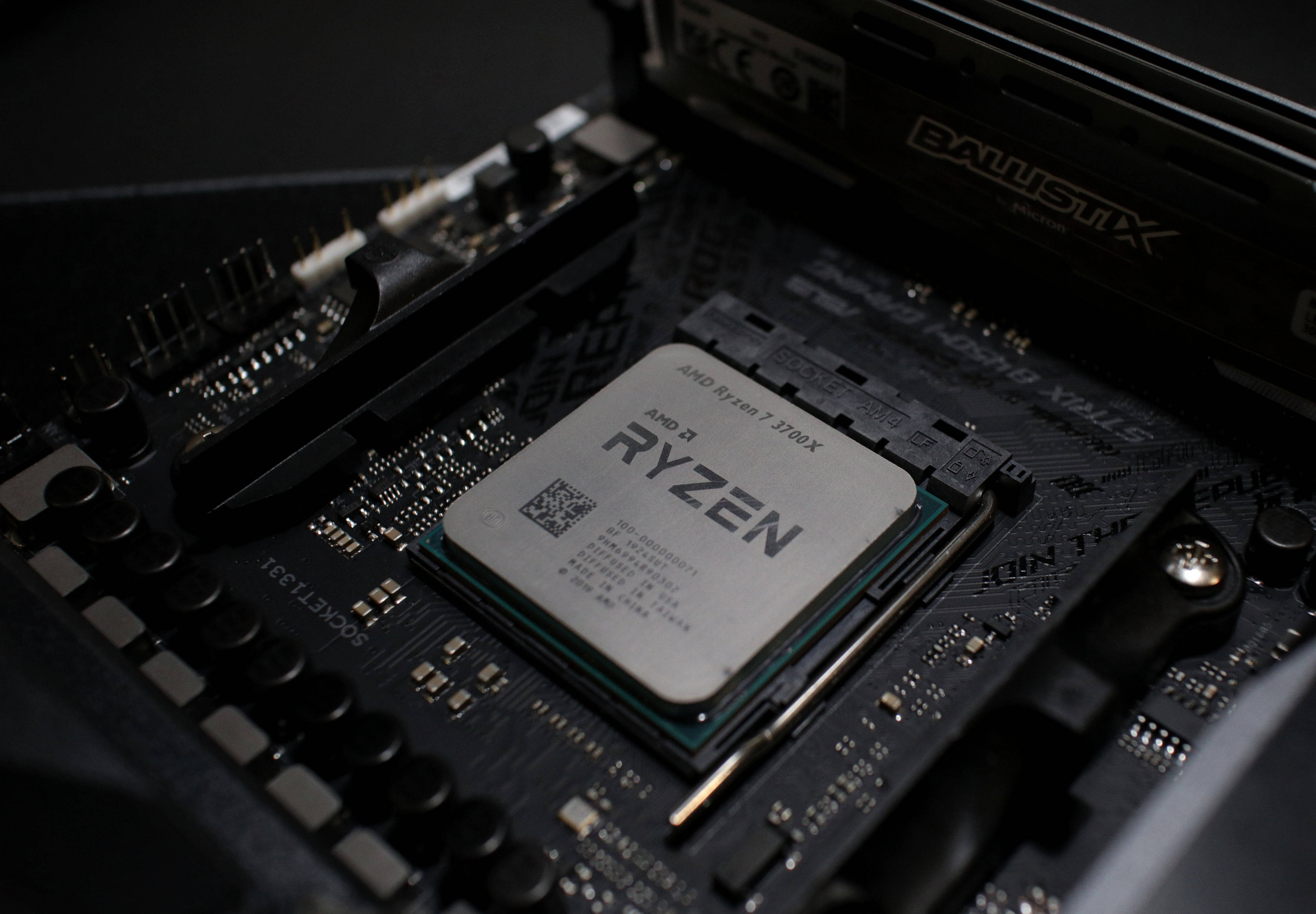 4K 桌布 壁紙 — AMD Ryzen 7 3700X CPU 安裝在黑色主機板上的特寫，可見 RAM 插槽和電路，在戲劇性燈光下。