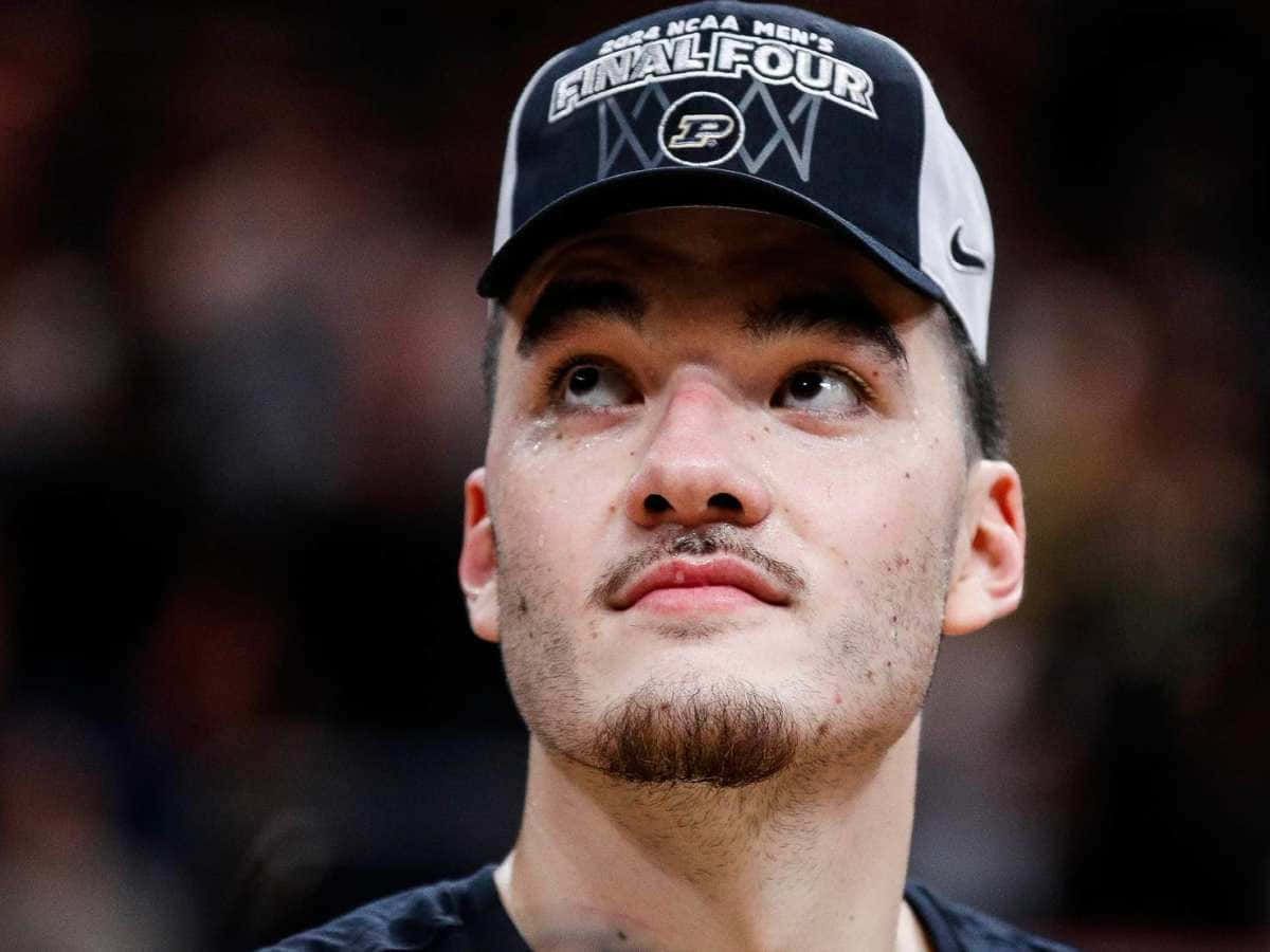  壁紙 — 一名戴著2024年NCAA男子四強賽帽子的籃球運動員，專注地向上看的特寫。