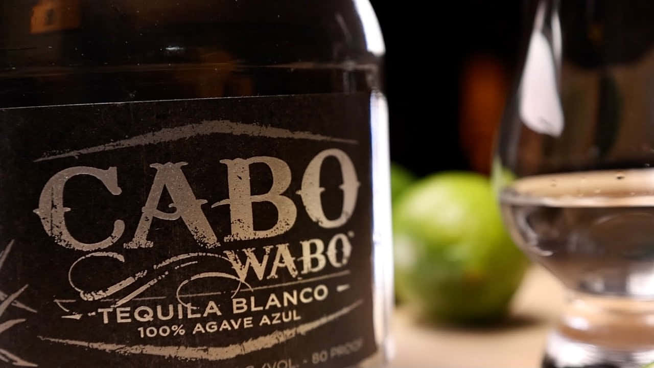  壁紙 — 木質表面上嘅Cabo Wabo Tequila Blanco酒樽、酒杯同青檸嘅特寫。