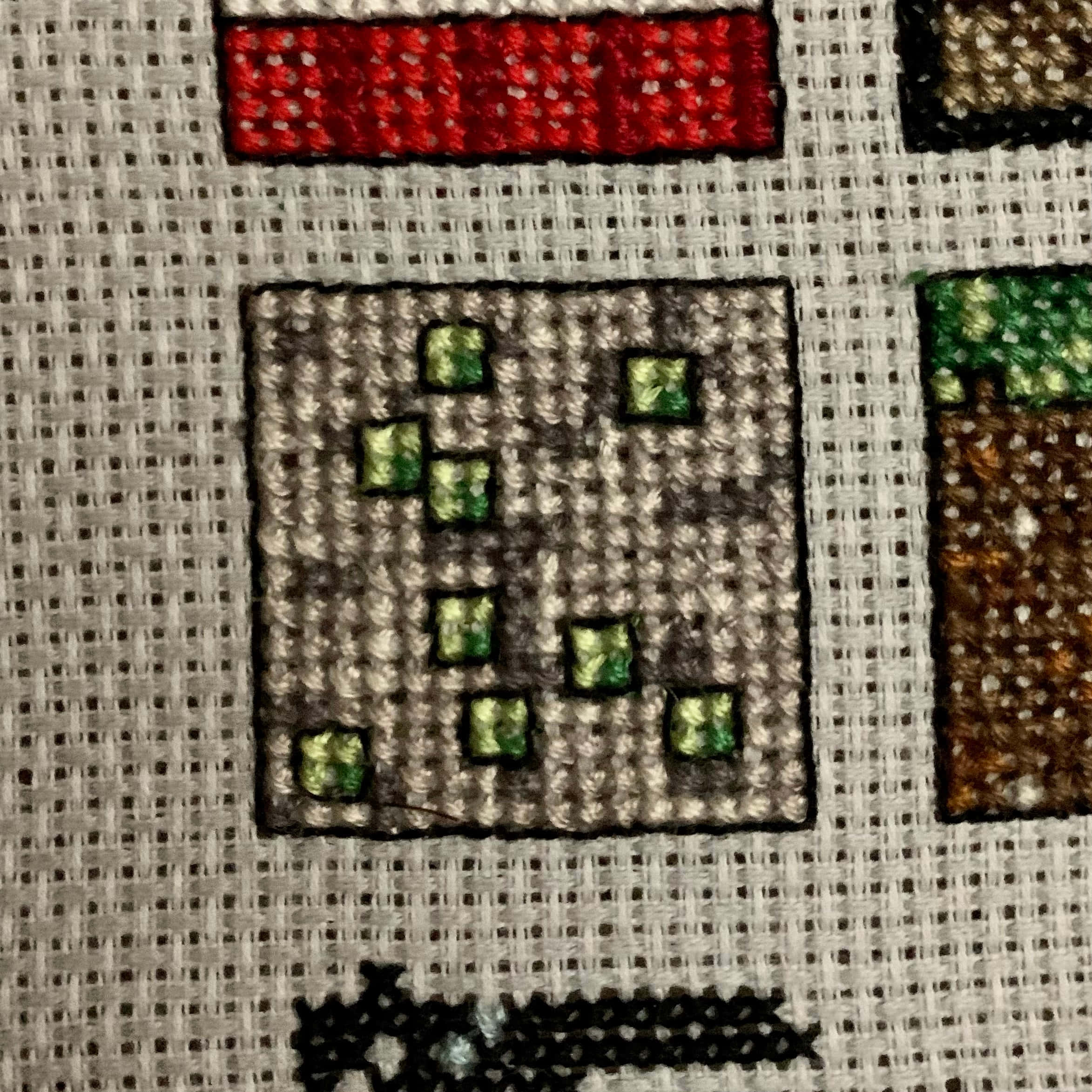 Minecraft Emeralds 桌布 壁紙 — 刺繡十字繡嘅特寫，喺有質感嘅布料上用鮮豔嘅線色描繪Minecraft方塊。