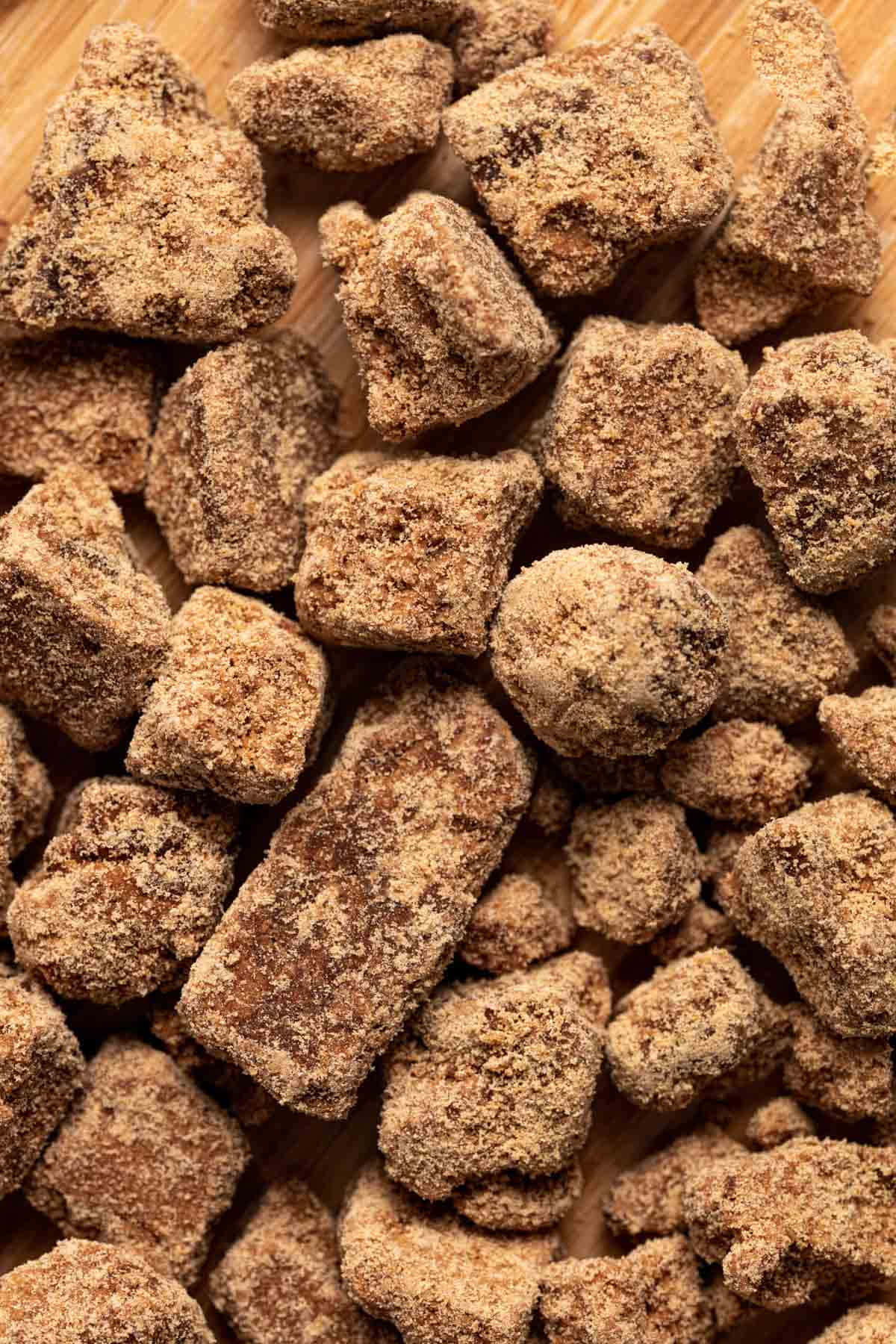 壁紙 — 木質表面上堆疊的不規則棕色糖衣零食特寫。