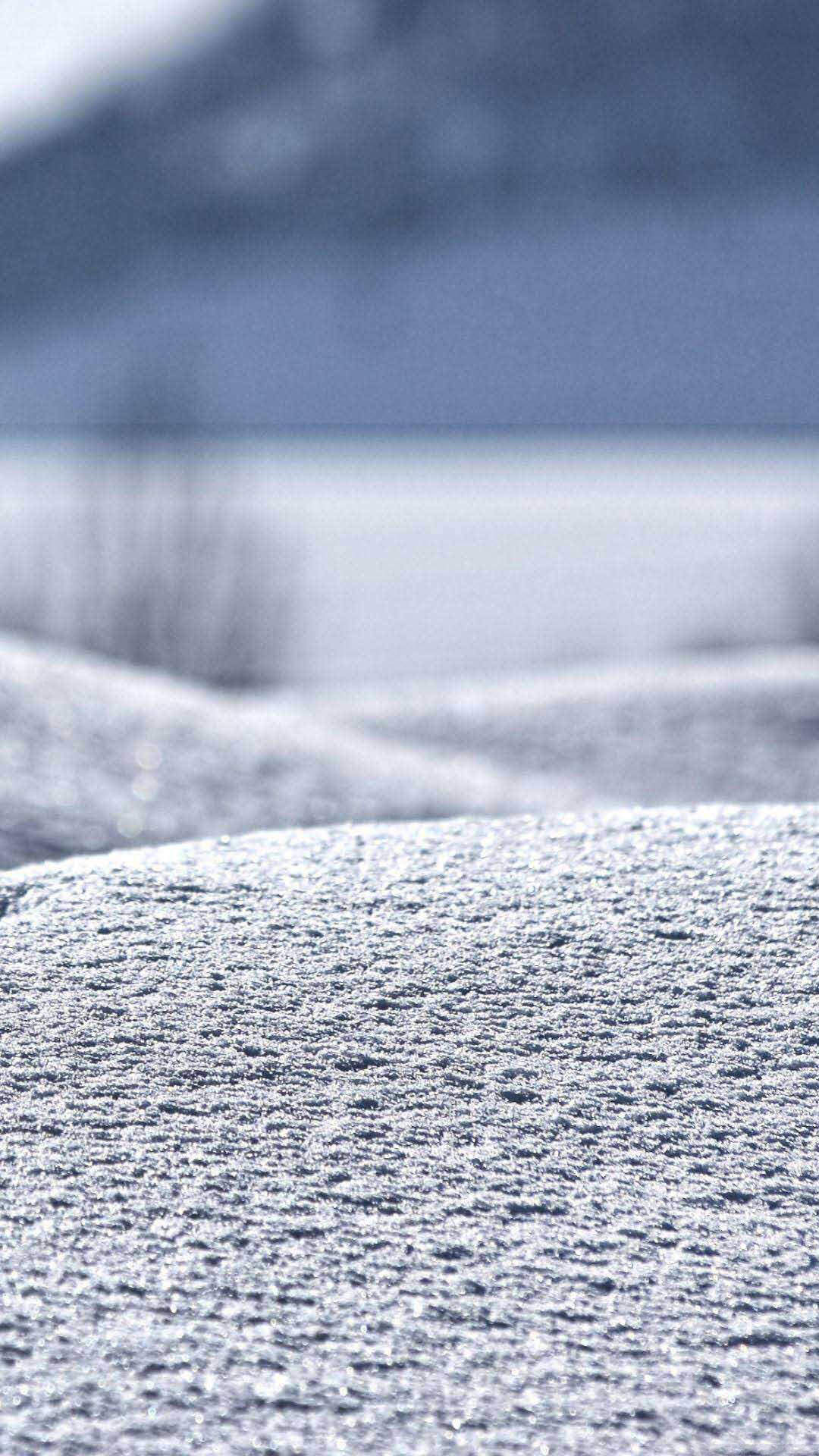 白雪覆蓋的地面，遠山在柔焦中。