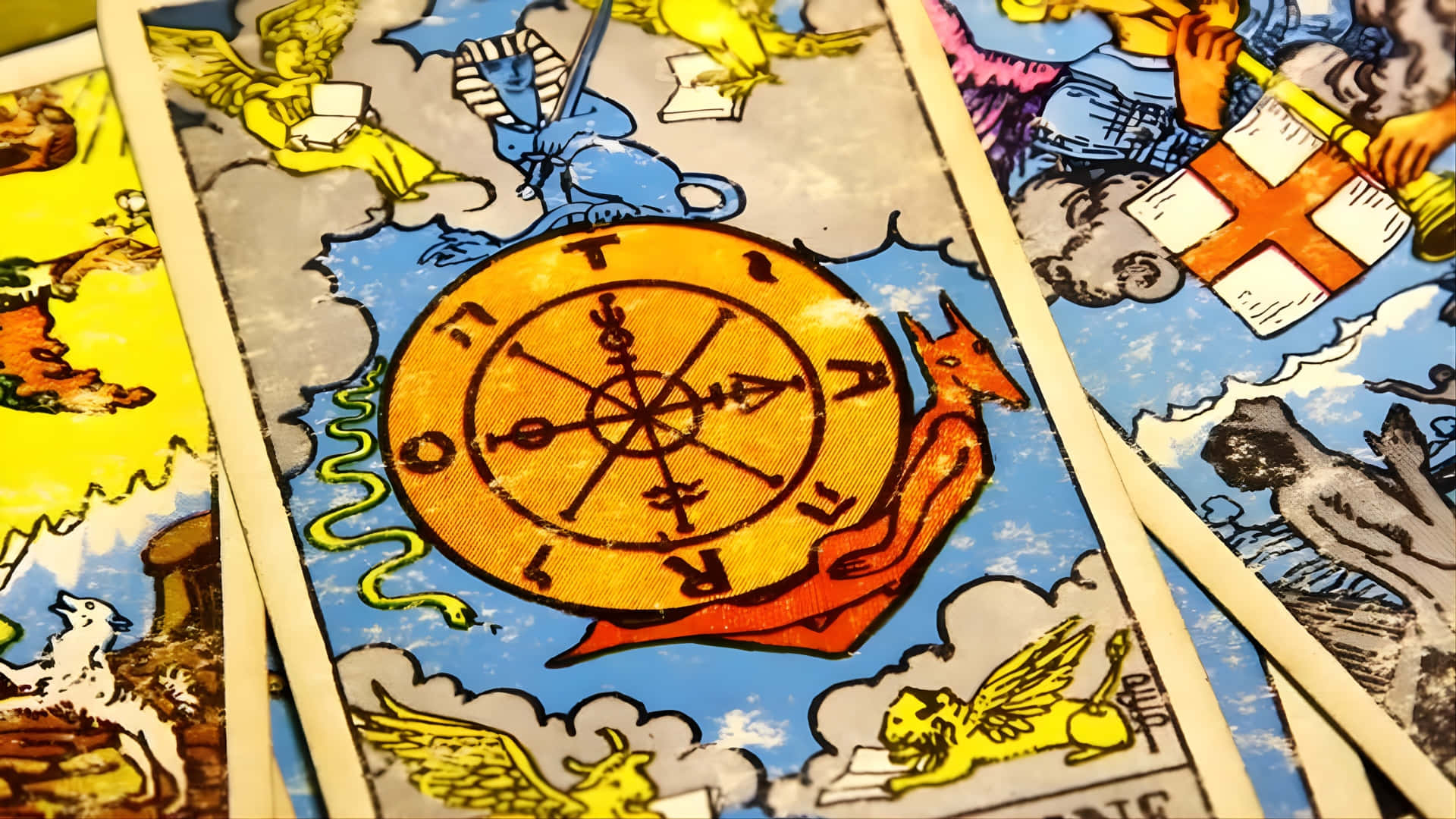 壁紙 — 復古塔羅牌特寫，帶有複雜的神話插圖和中央金色指南針狀符號。