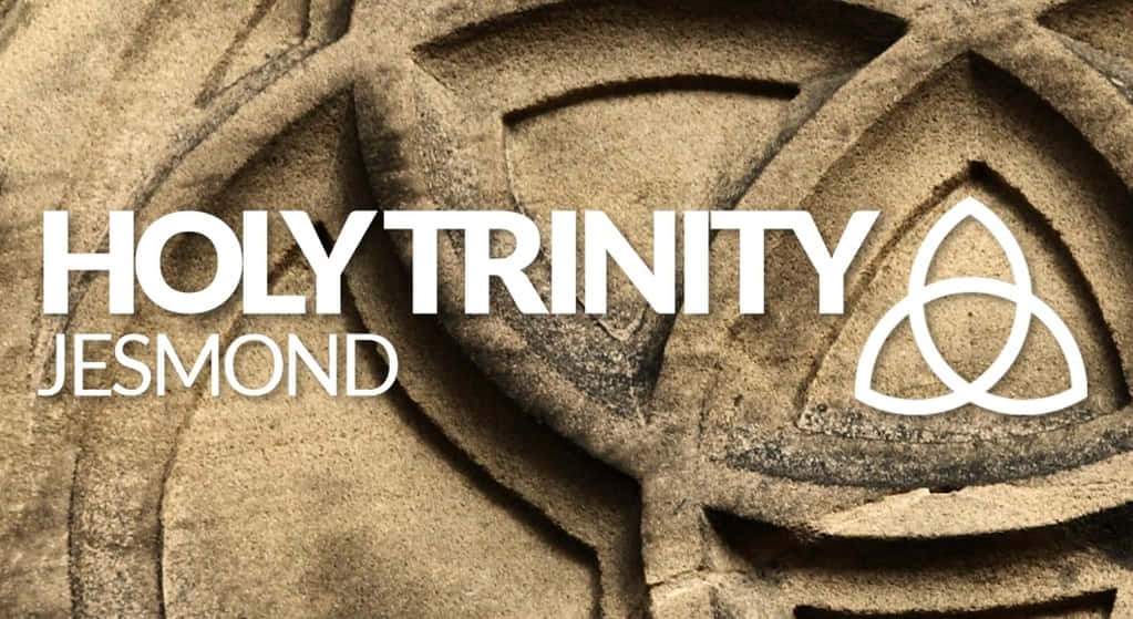  壁紙 — 風化石雕嘅特寫，上面有白色字嘅「HOLY TRINITY JESMOND」同三位一體結符號。