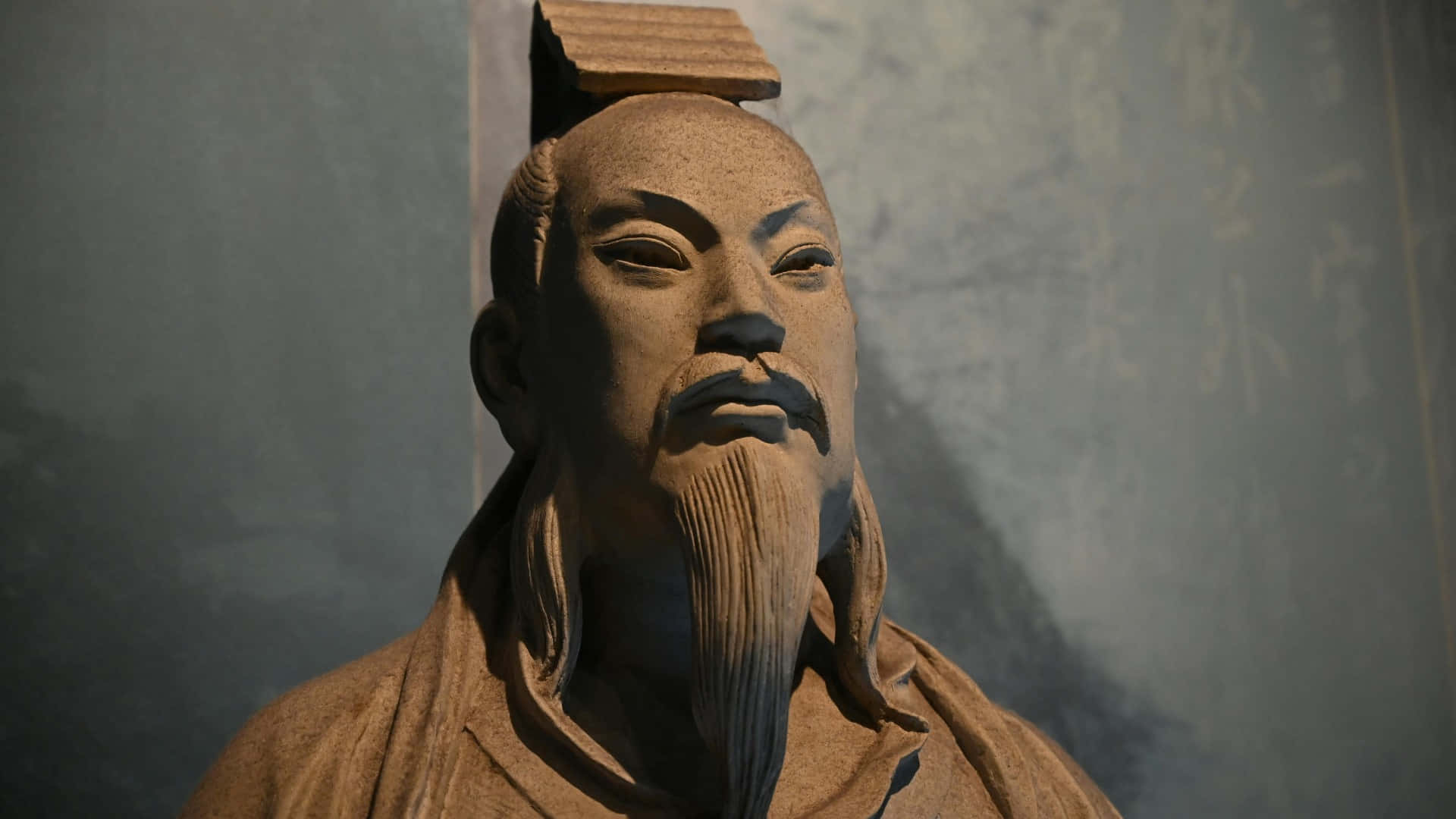  壁紙 — 古代中國學者嘅風化石像特寫，佢有長鬍鬚同傳統頭飾。
