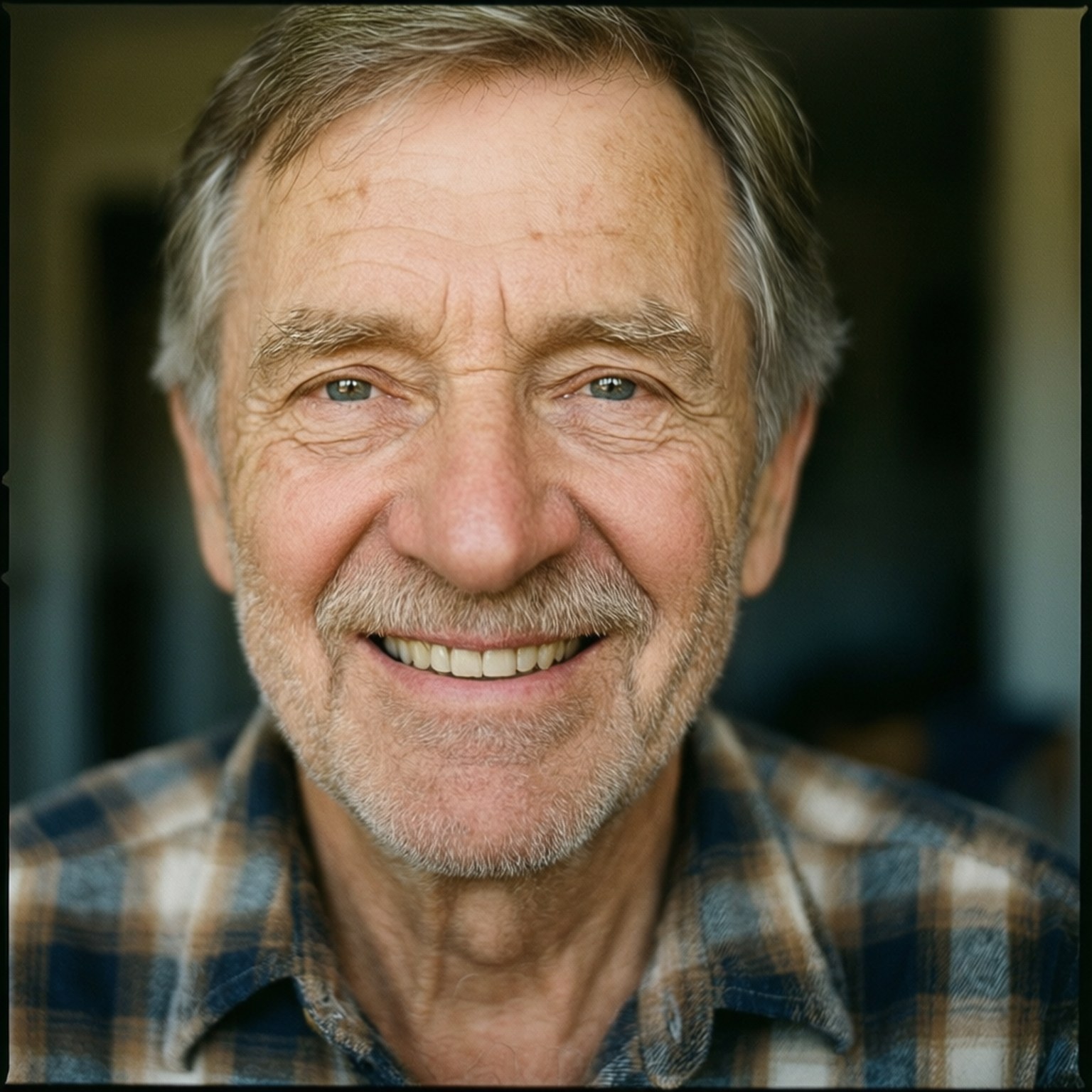 Warm Smile Portrait 壁紙 — 一位開朗長者的特寫肖像，灰白頭髮，溫暖笑容，穿著格仔襯衫。