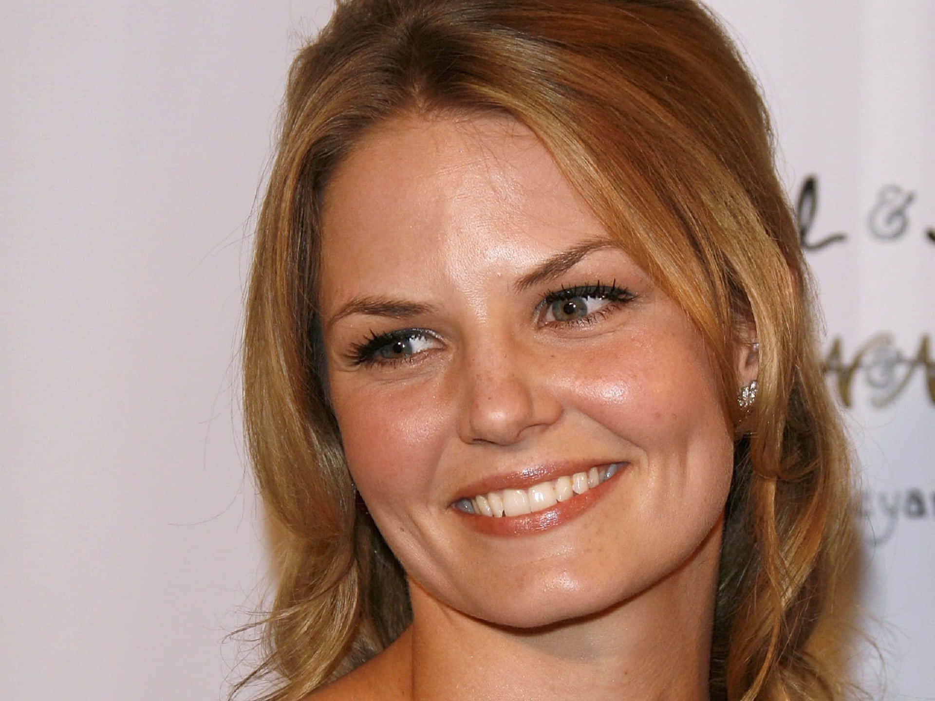 jennifer morrison 桌布 壁紙 — 一個微笑的金髮女子特寫肖像，背景為白色，眼睛明亮。
