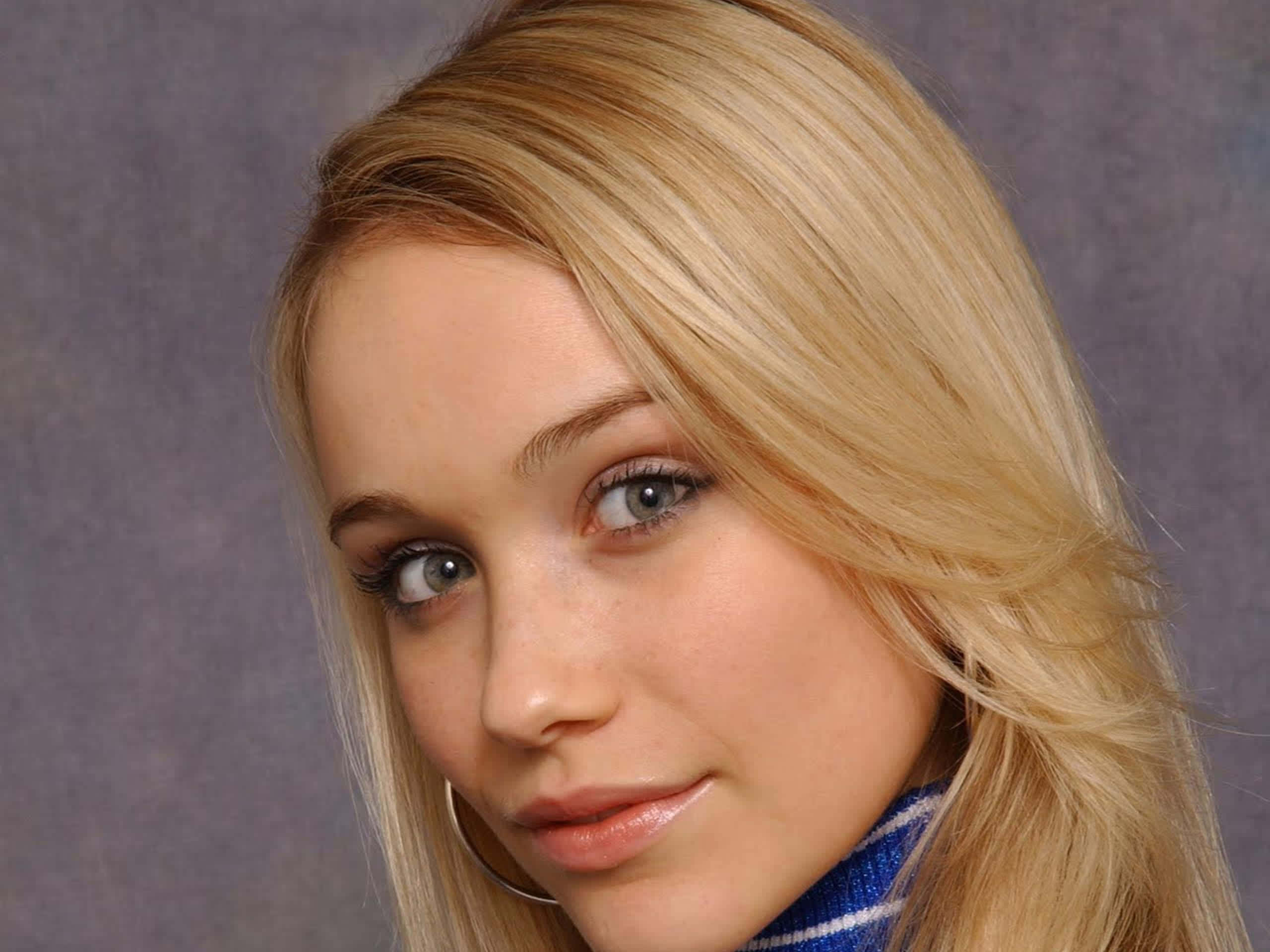 Katrina Bowden 桌布 壁紙 — 年輕金髮藍眼女子在柔和灰色背景前微笑的特寫肖像。