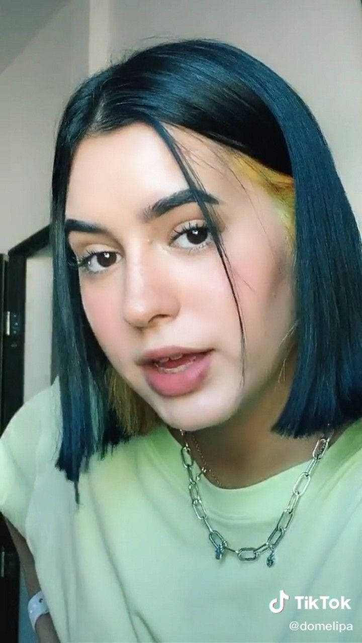 藍黃髮色的年輕女子佩戴鏈條項鍊。