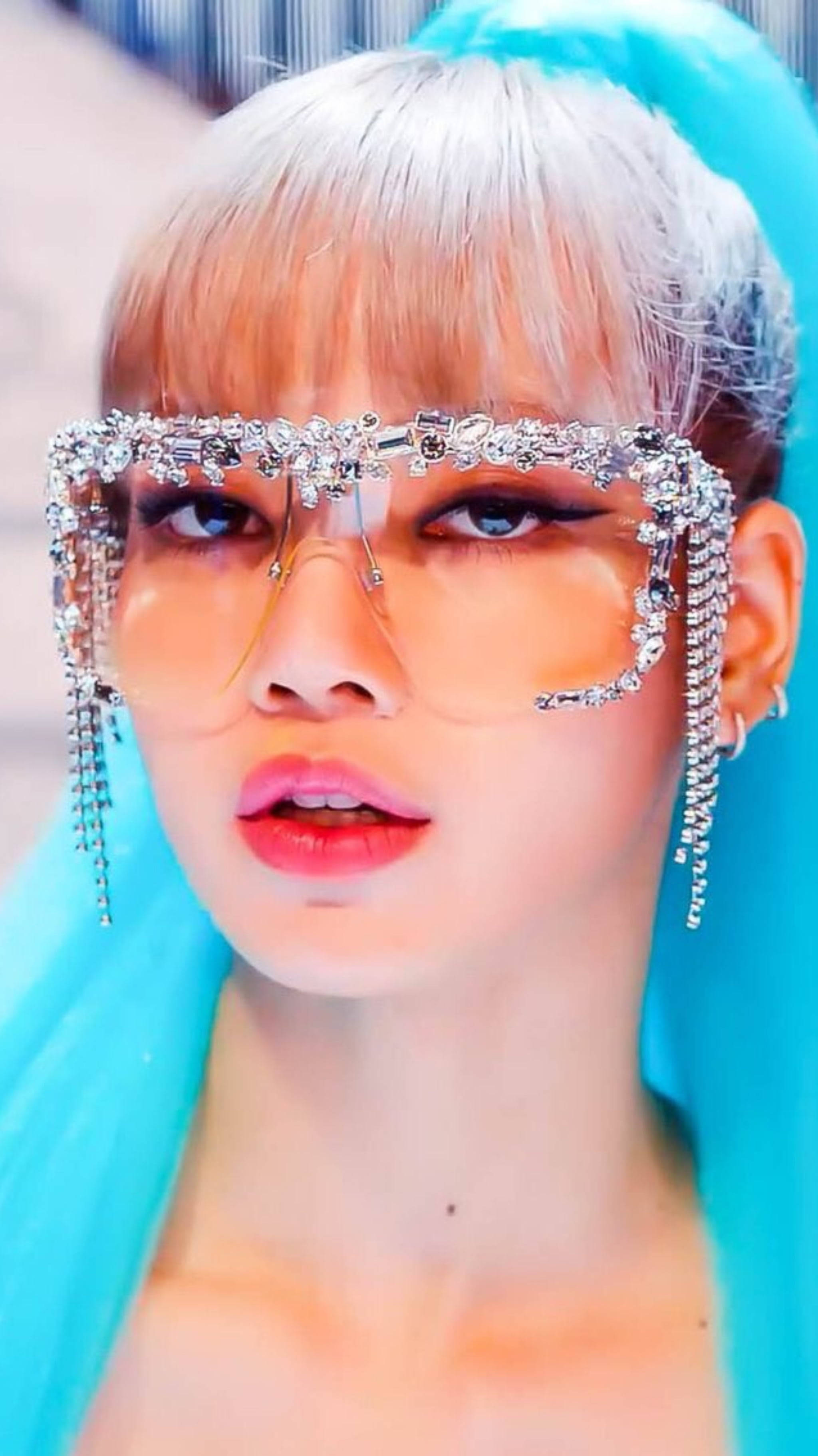 Lisa BLACKPINK《Kill This Love》高清照 壁紙 — 一個近距離肖像，人物擁有鉑金色頭髮和超大水晶裝飾眼鏡，背景是明亮的藍綠色。