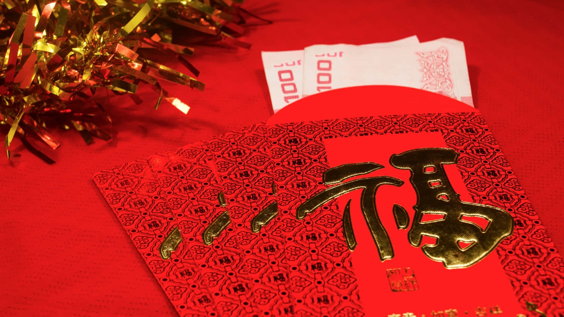  壁紙 — 紅色中國新年利是封特寫，內有金箔「福」字和錢，旁邊有金色閃粉。