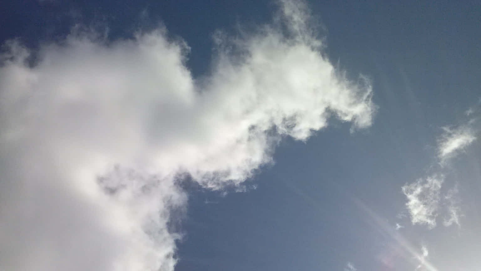 晴朗藍天上漂浮的大片白雲，可見陽光